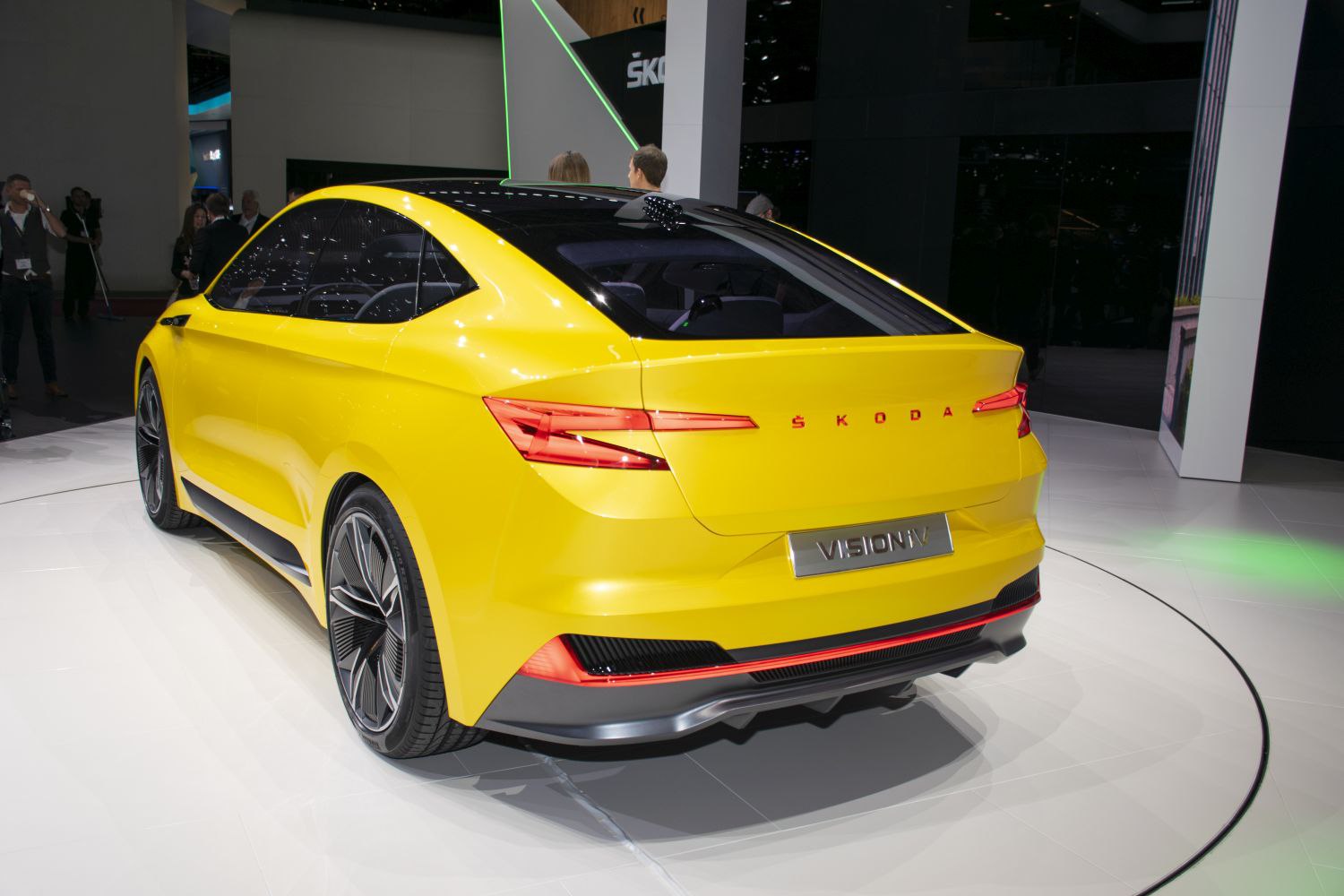 Rear view of yellow electric crossover with sleek LED taillights and panoramic black roof.