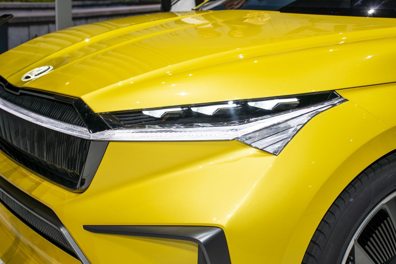 Close-up of front LED headlight and grille on yellow car body