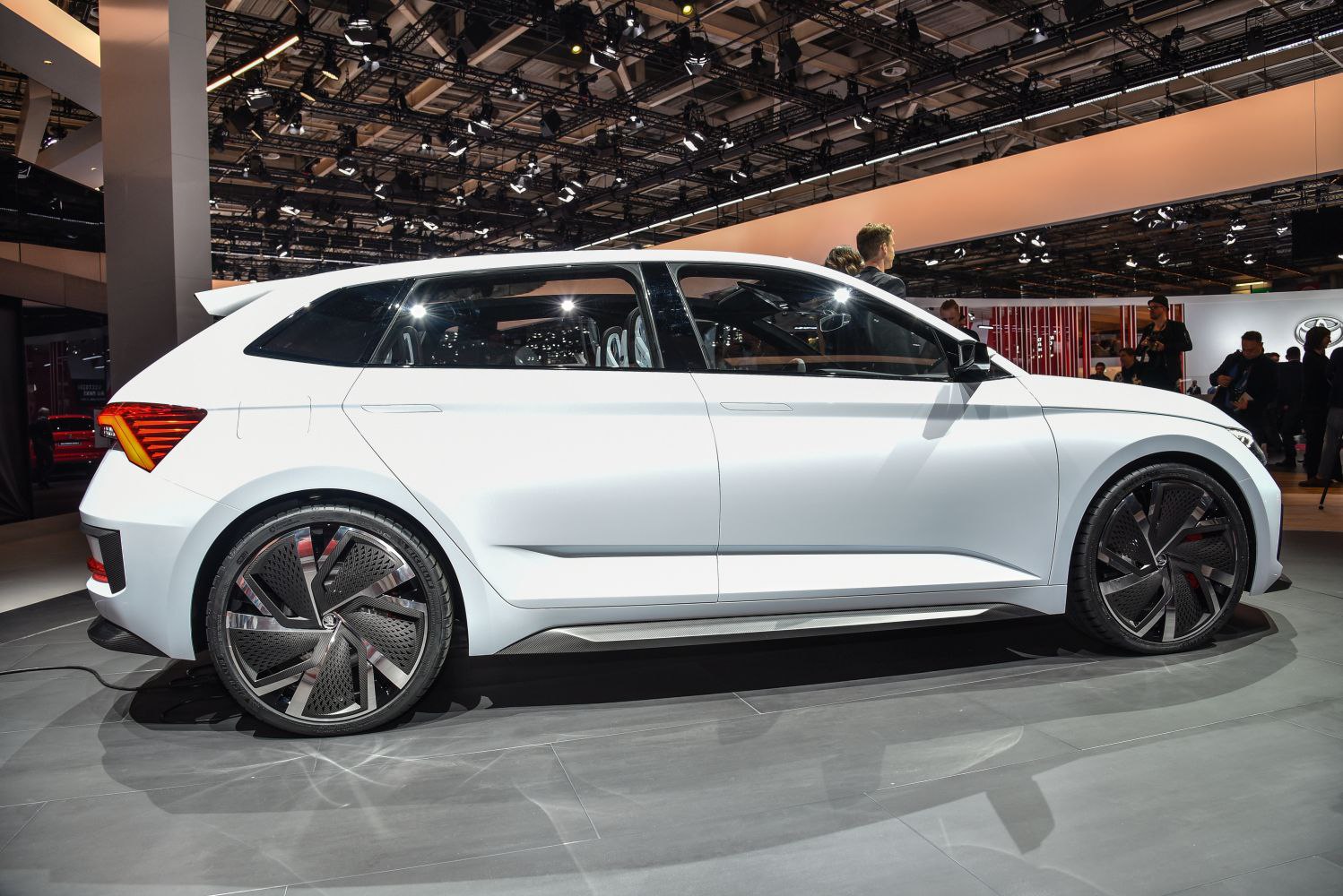 White futuristic hatchback with aerodynamic, detailed alloy wheels and sharp body lines.