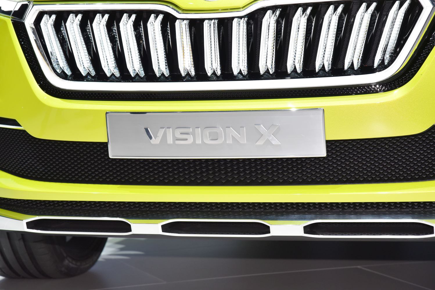 Close-up of front grille with vertical illuminated slats and Vision X badge