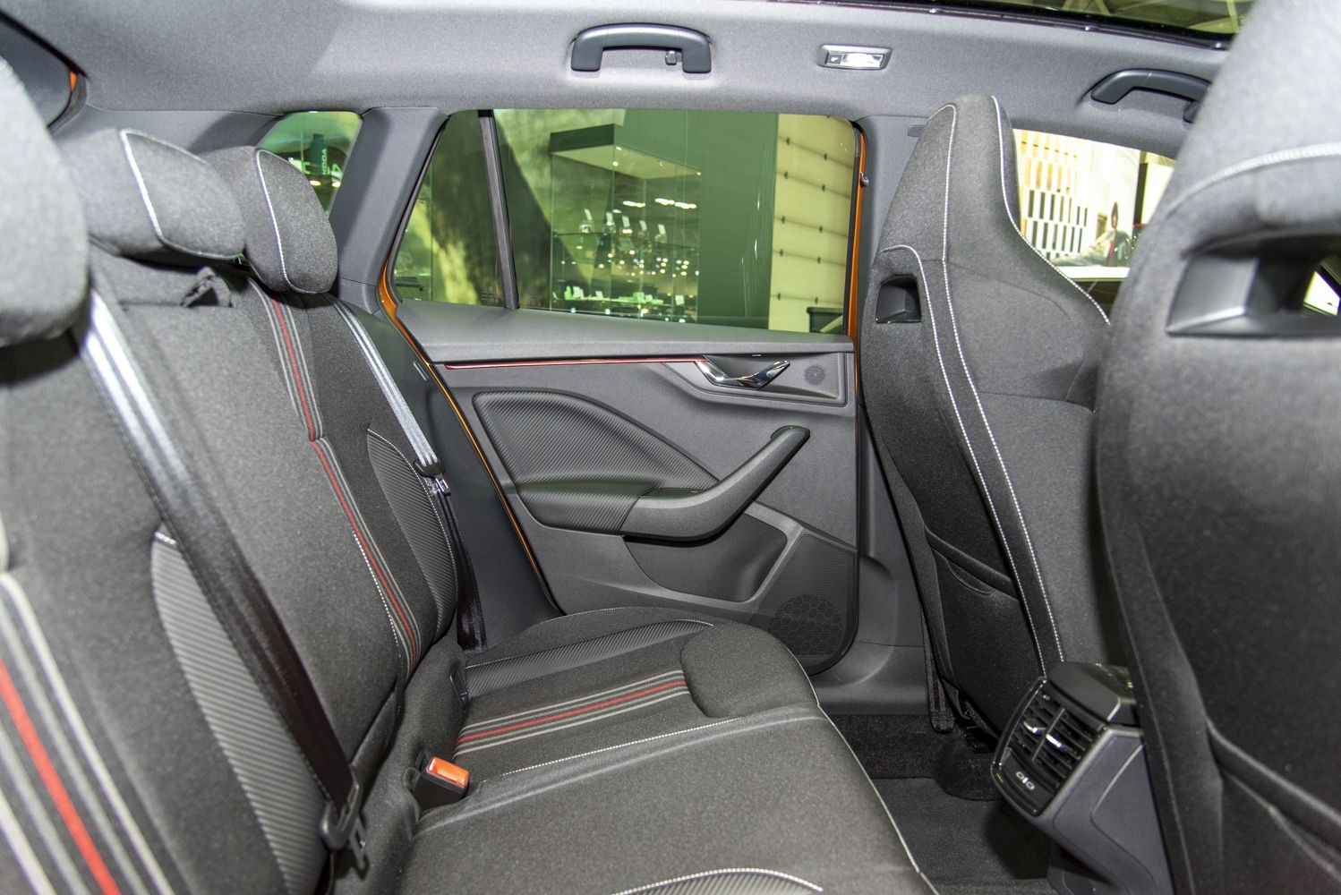 Rear seat and door panel with stitched upholstery and rear air vents