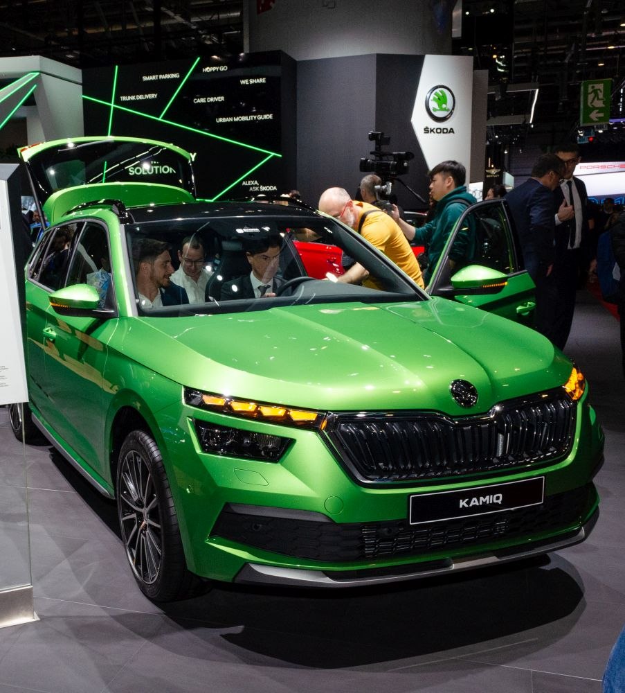 Green car with distinct front grille and split LED headlight design