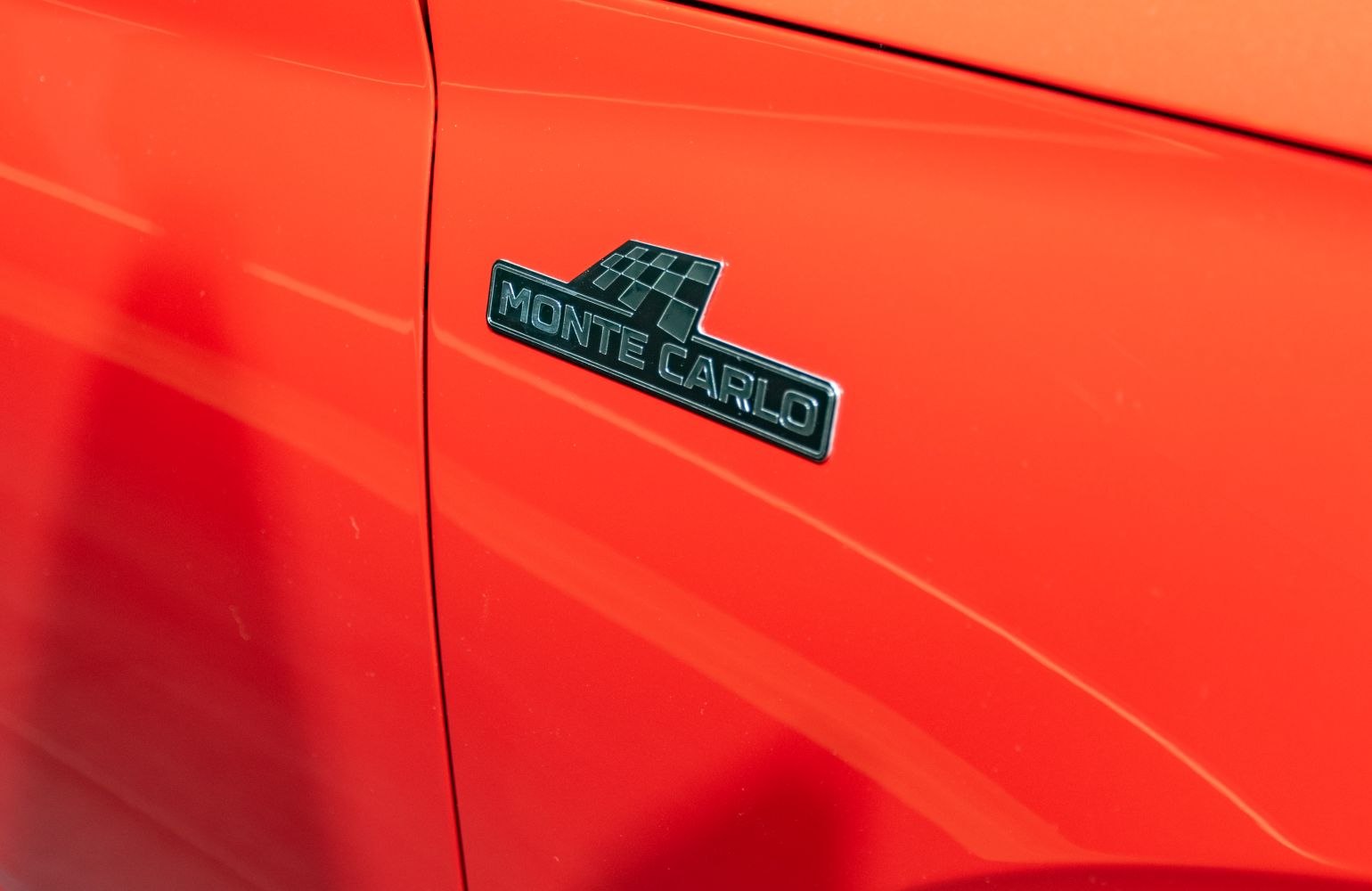 Close-up of Monte Carlo badge on red vehicle body panel
