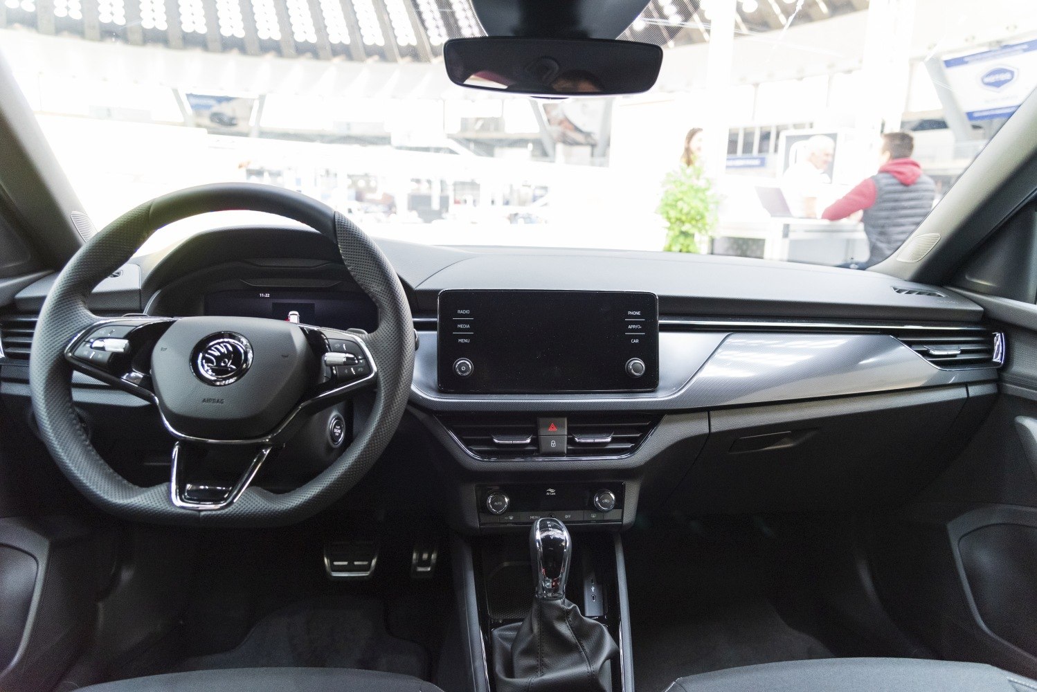 Modern car interior dashboard with multifunction steering wheel and central touchscreen display