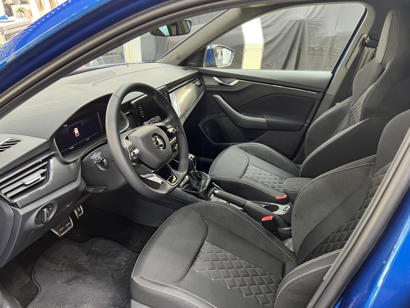 Modern digital dashboard and quilted fabric seats in car interior