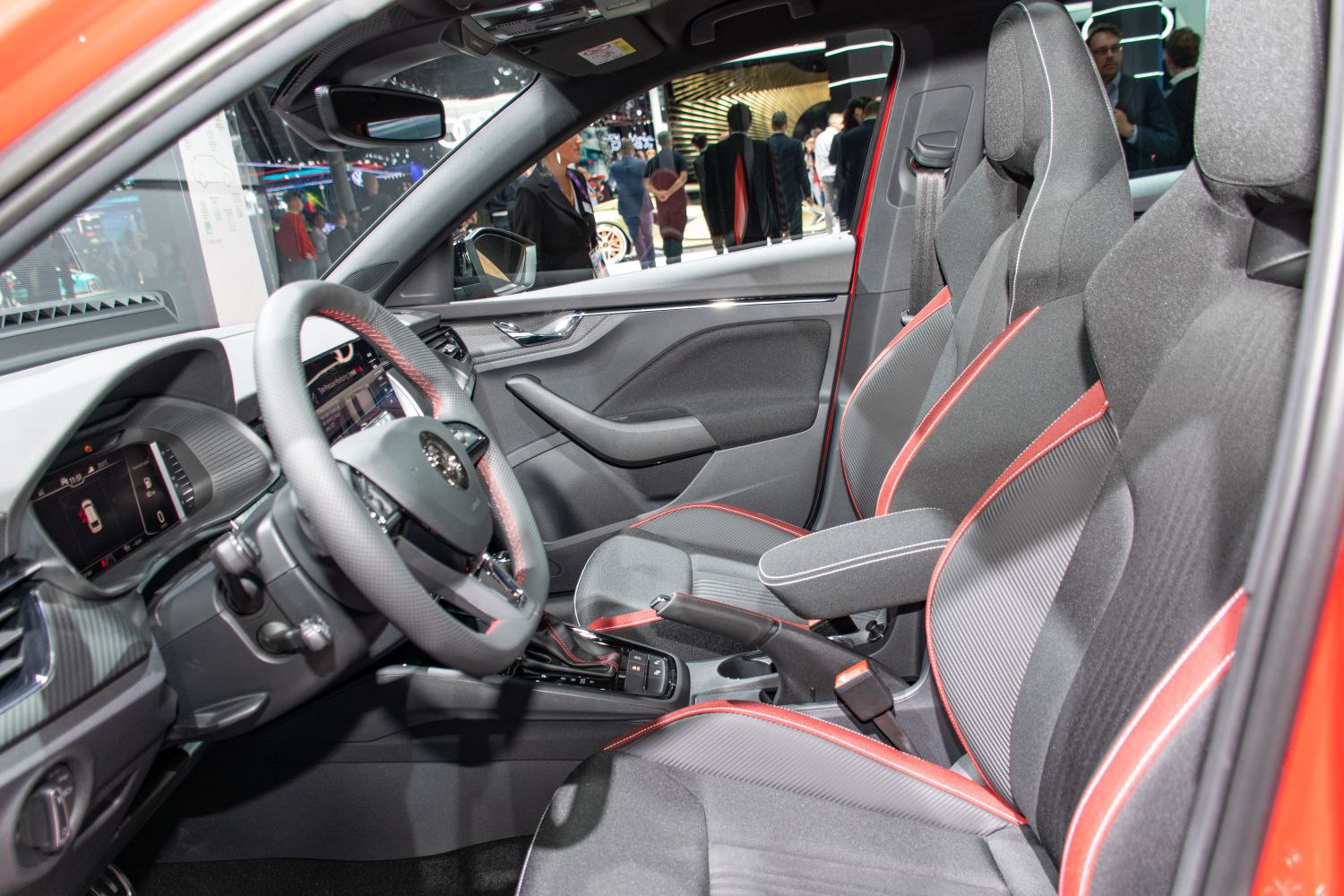 Sporty front seats with red accents and digital dashboard