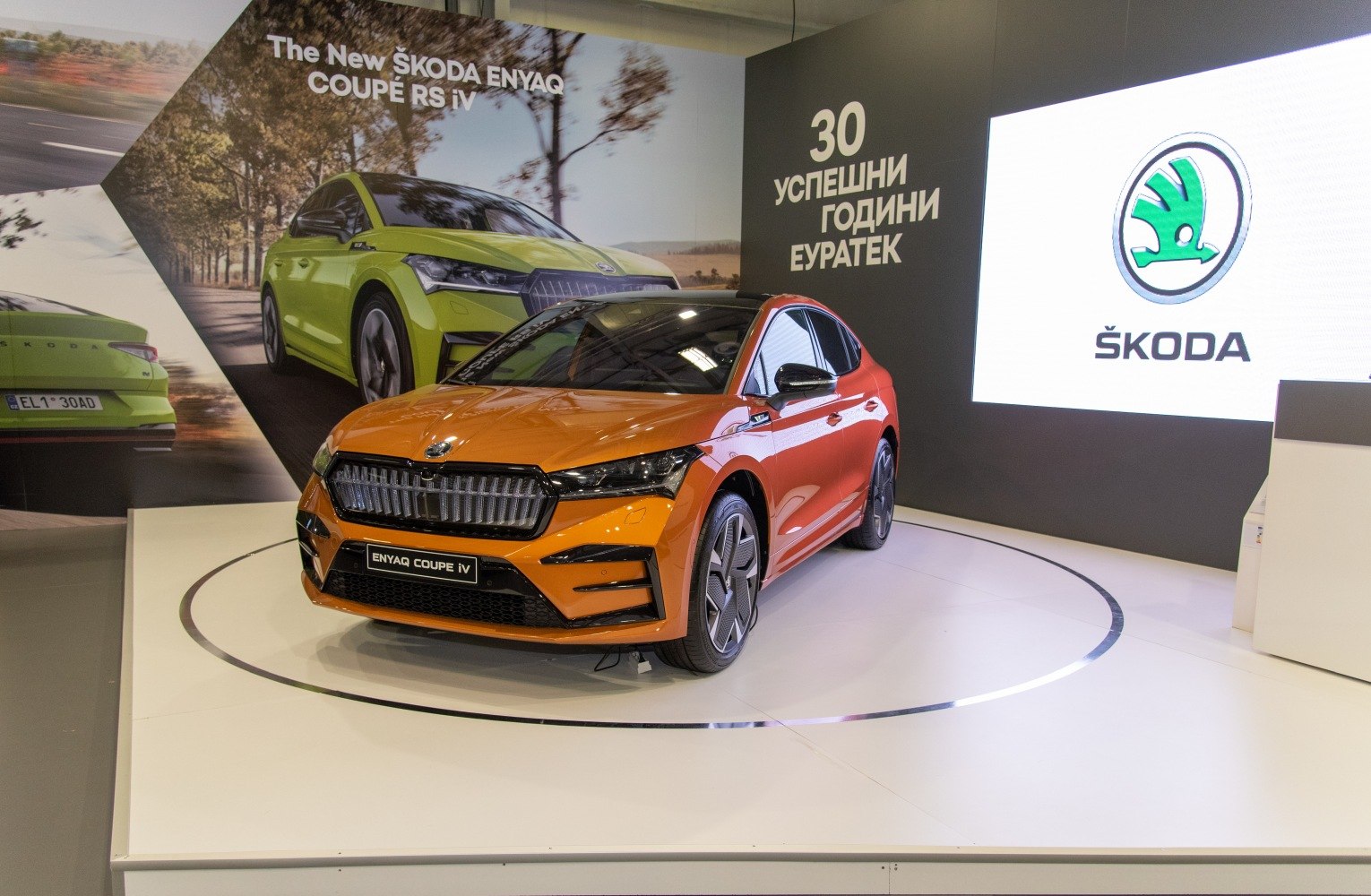 Front view of orange electric SUV with sleek grille and aerodynamic wheels