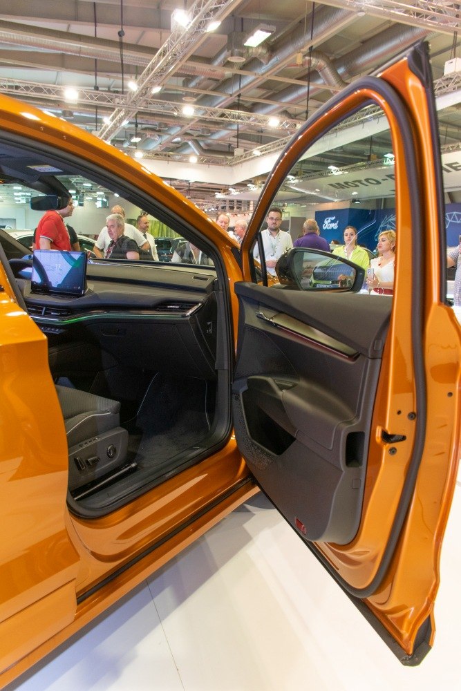 Open front door and dashboard interior with infotainment screen and seating