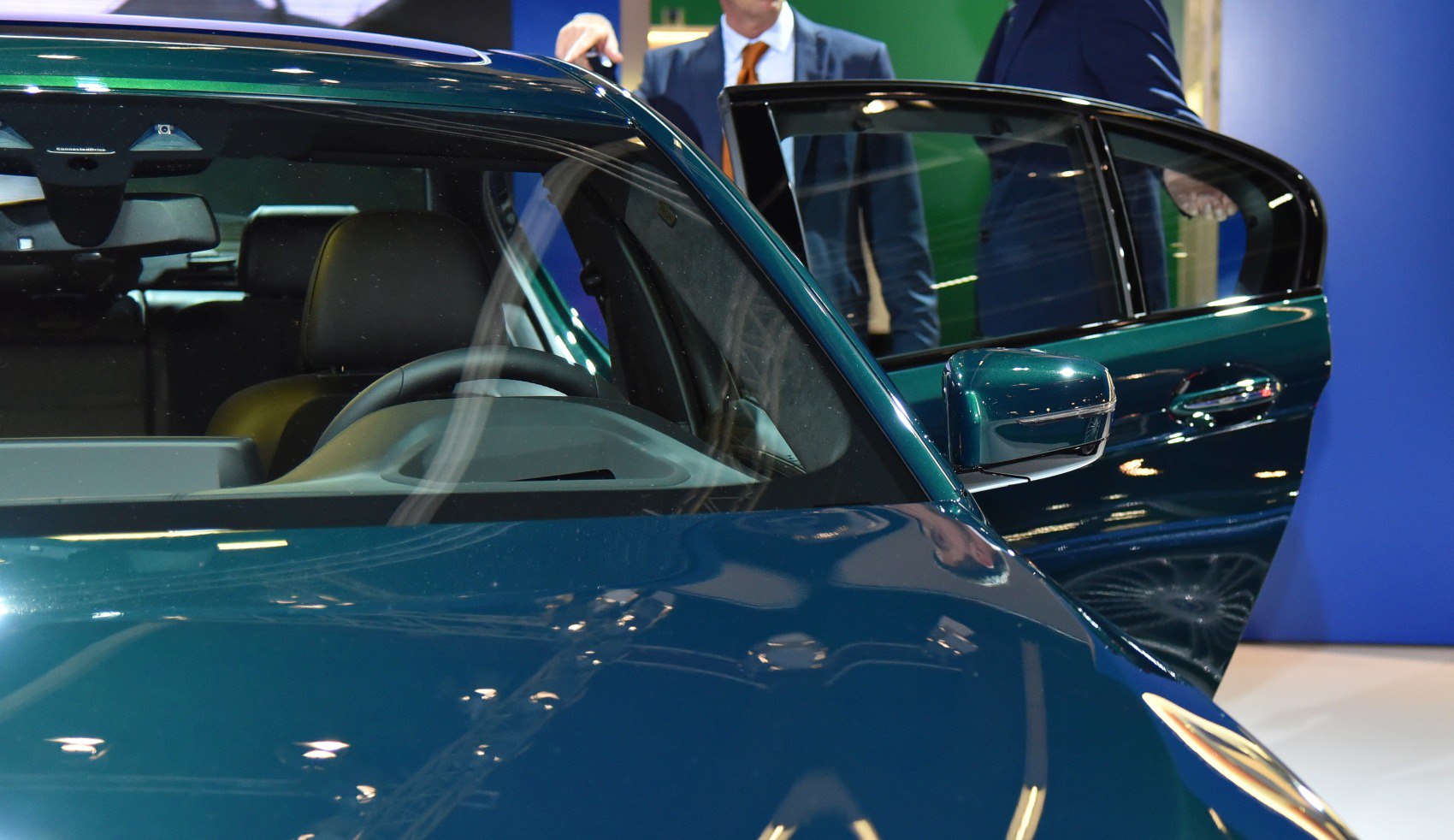 Luxury sedan interior with steering wheel and open rear door