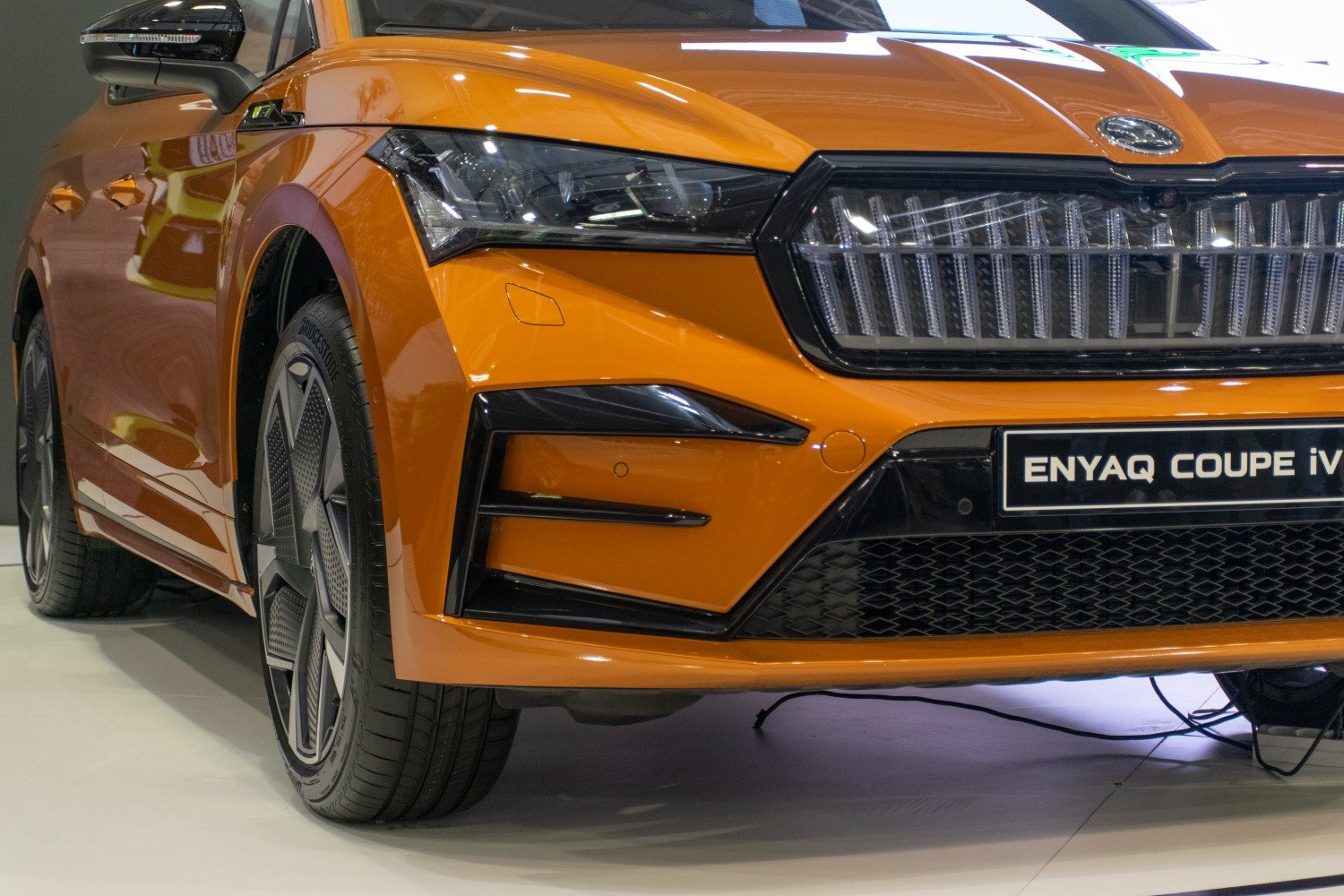 Close-up of front grille, headlight, and wheel of a modern electric SUV