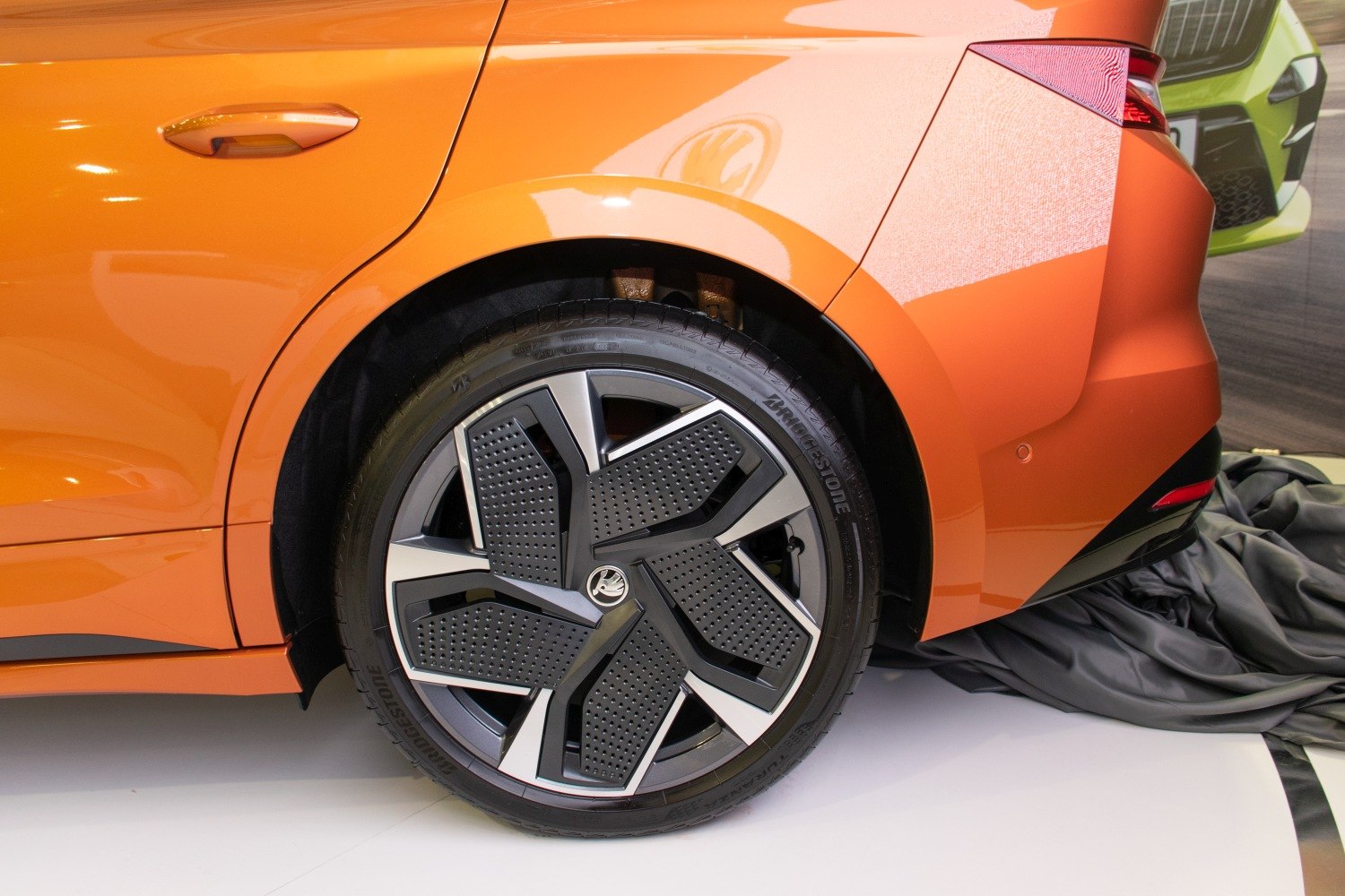 Rear wheel and tail light of an orange electric SUV