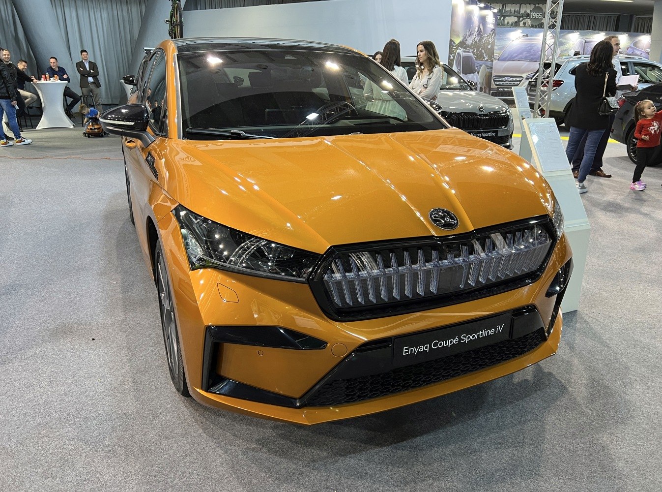 Sharp LED headlights and bold grille in front view of electric coupe