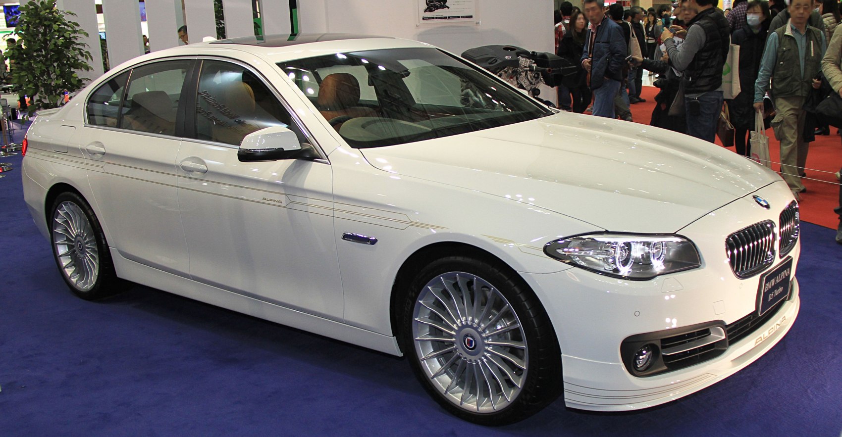 White luxury sedan with multi-spoke wheels and sleek profile