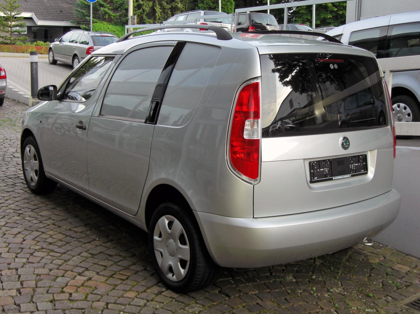 Compact silver panel van with roof rails and sliding rear side door