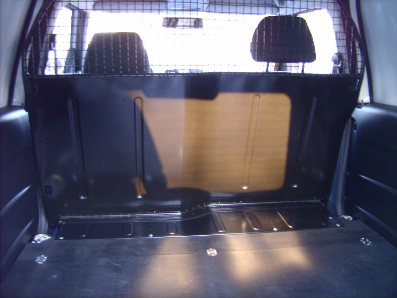 Cargo area with protective metal partition and cargo floor