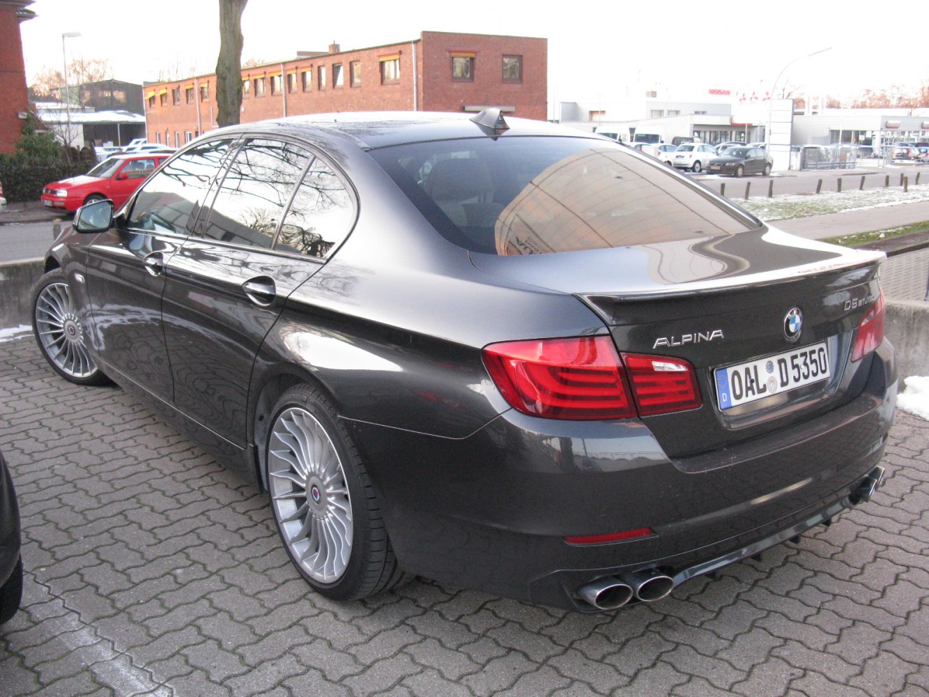 Rear view with multi-spoke alloy wheels and quad exhausts