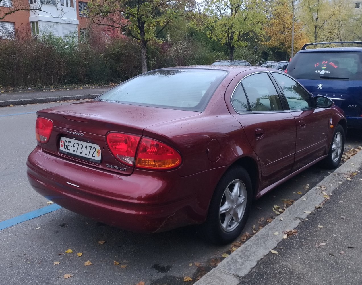 Rear and side view of a four-door sedan with red taillights.