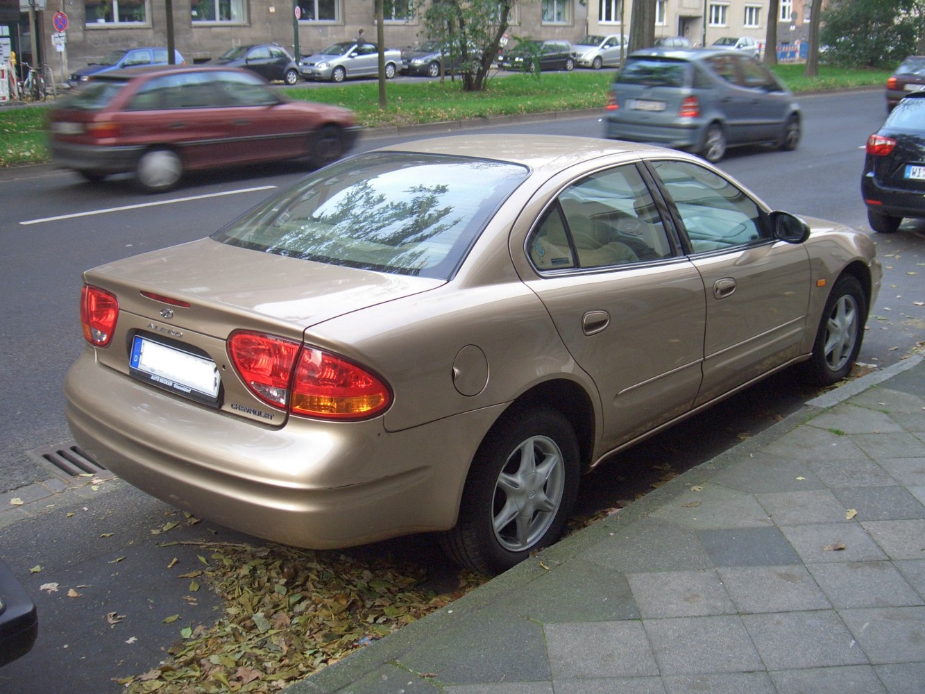Rear and side view of beige sedan with distinct taillights and fuel cap