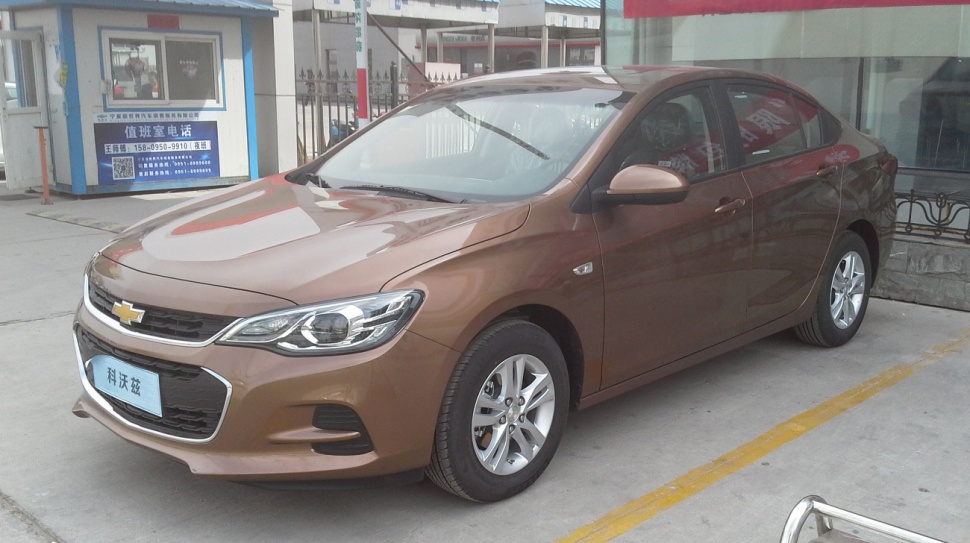 Brown sedan with front-side view, alloy wheels, and sleek body lines