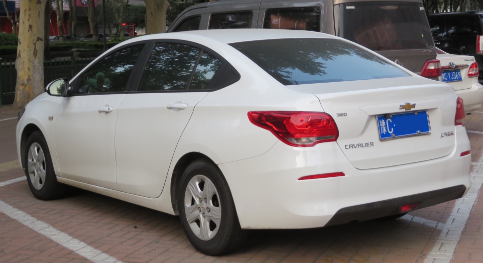 Rear side view of white sedan with distinct tail lights
