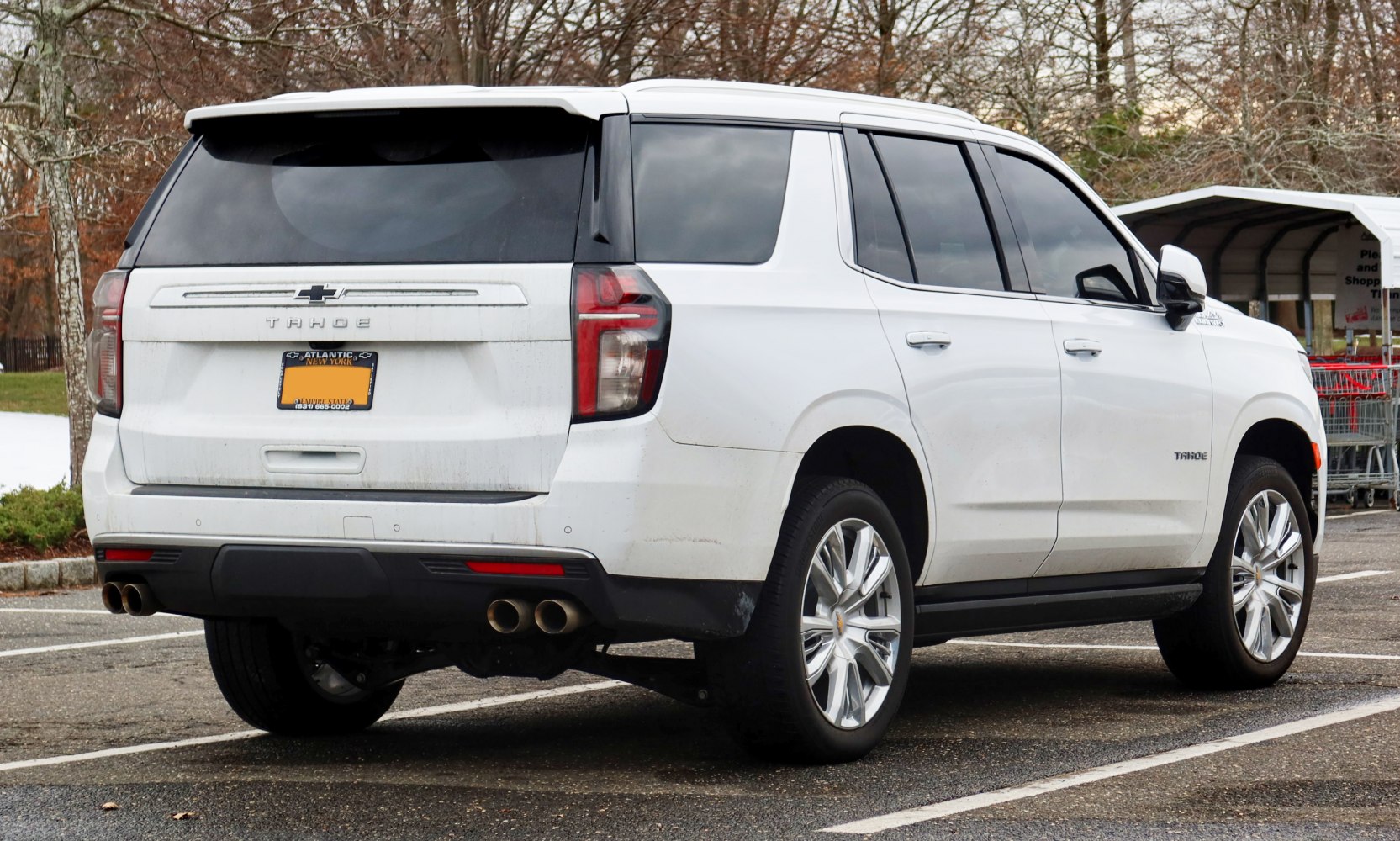 Rear and side view of white SUV with quad exhaust and tinted windows