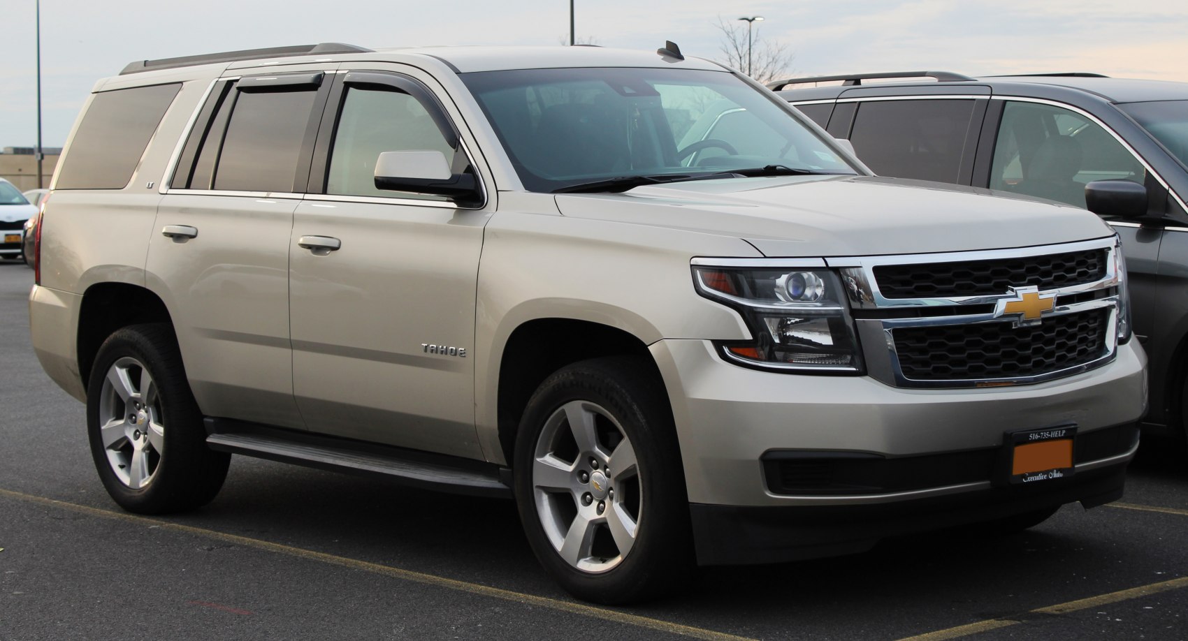 Front side view of SUV with prominent grille and angular headlights.