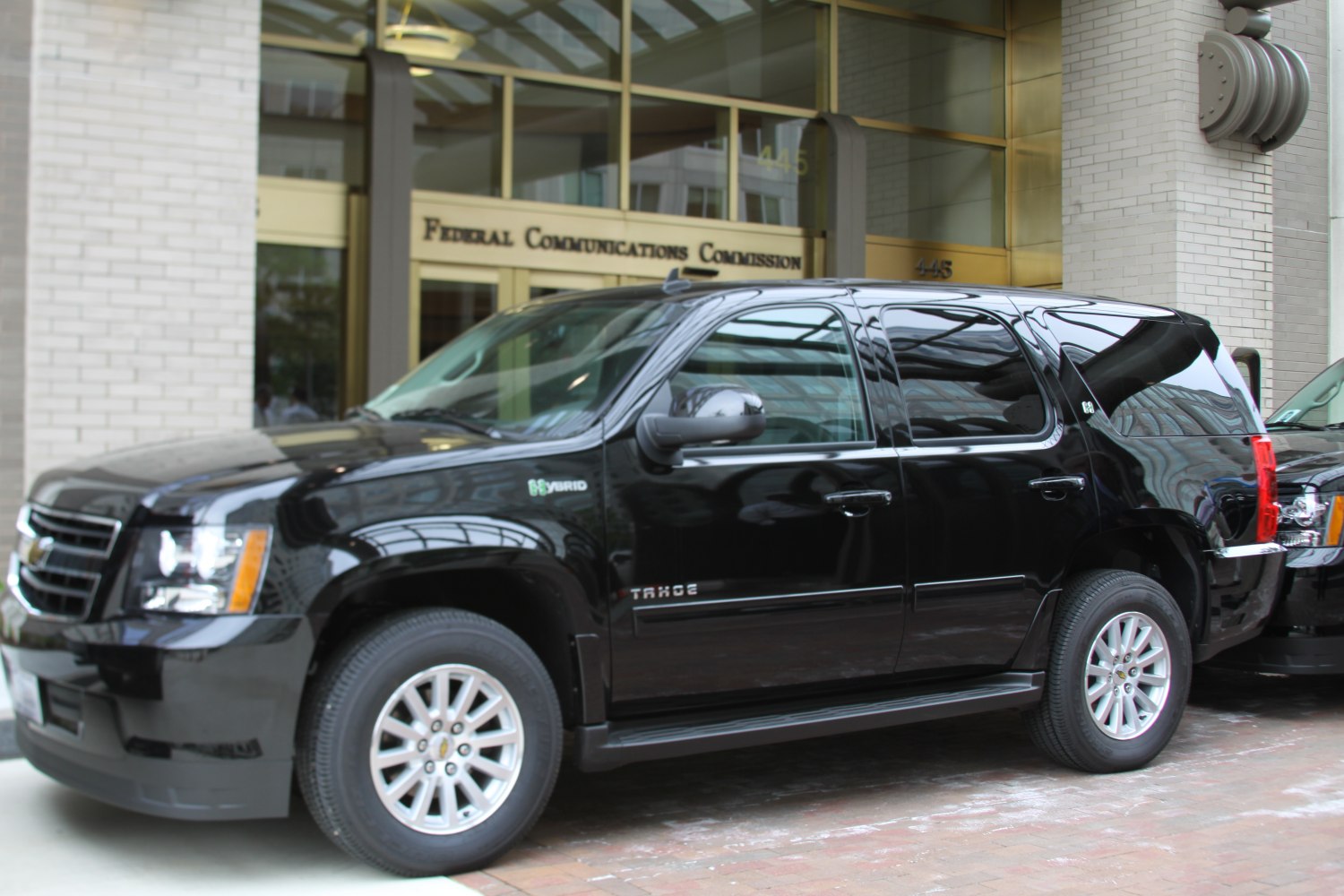 Black full-size SUV hybrid featuring alloy wheels and side steps