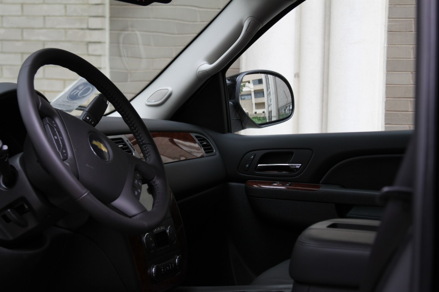 Leather steering wheel and wood trim dashboard with side mirror