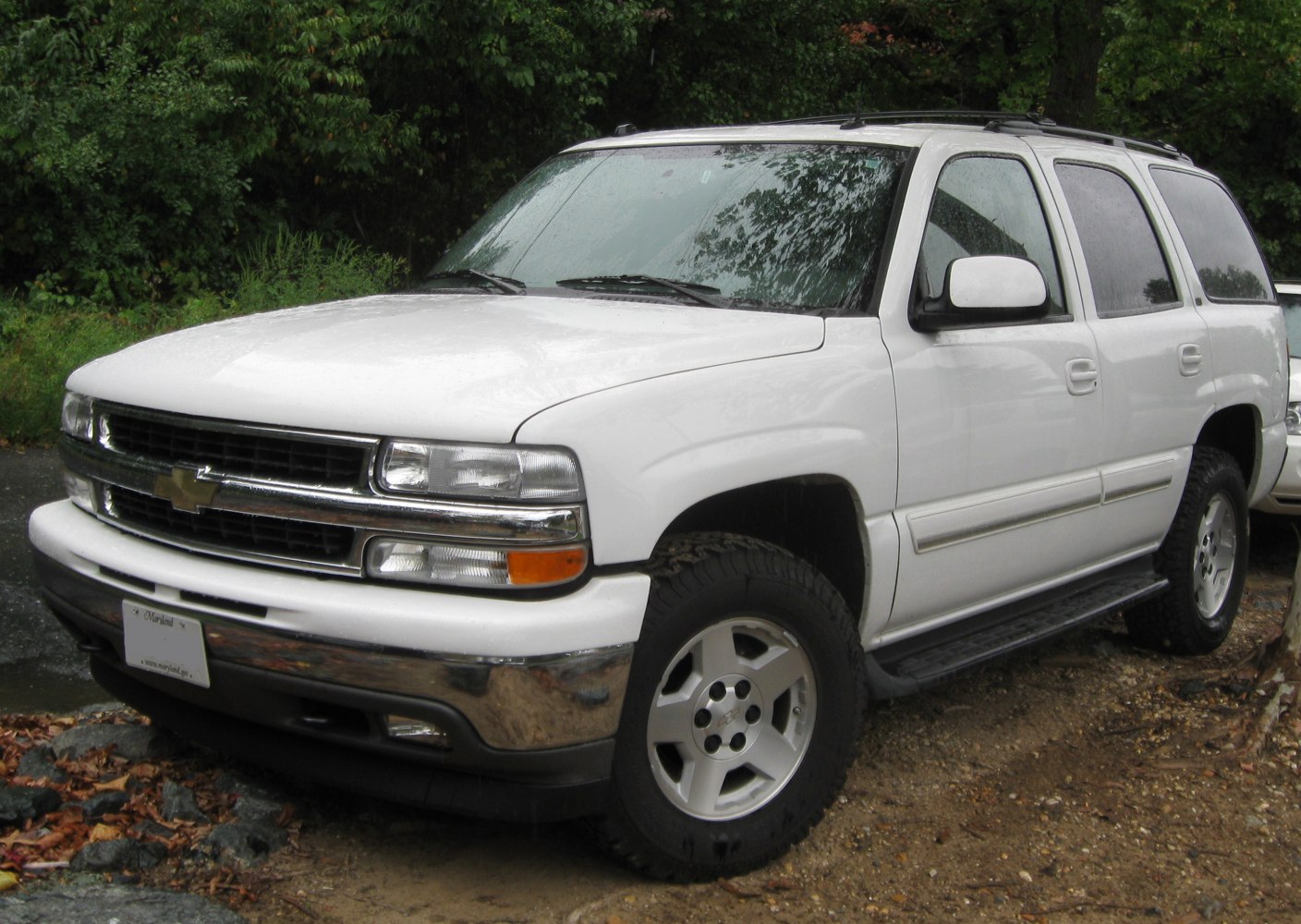 Front and side view of white SUV with chrome grille and off-road tires