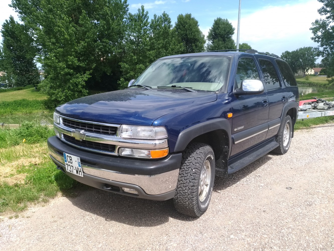Front-side view of SUV with chrome grille and rugged tires