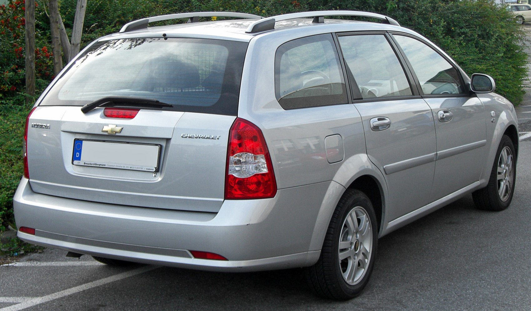 Rear view of a silver station wagon with roof rails and distinctive taillights