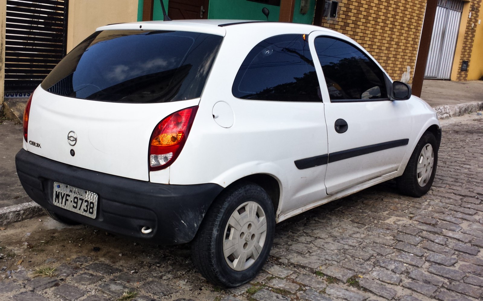 Rear side view of white hatchback showing taillights and tinted window
