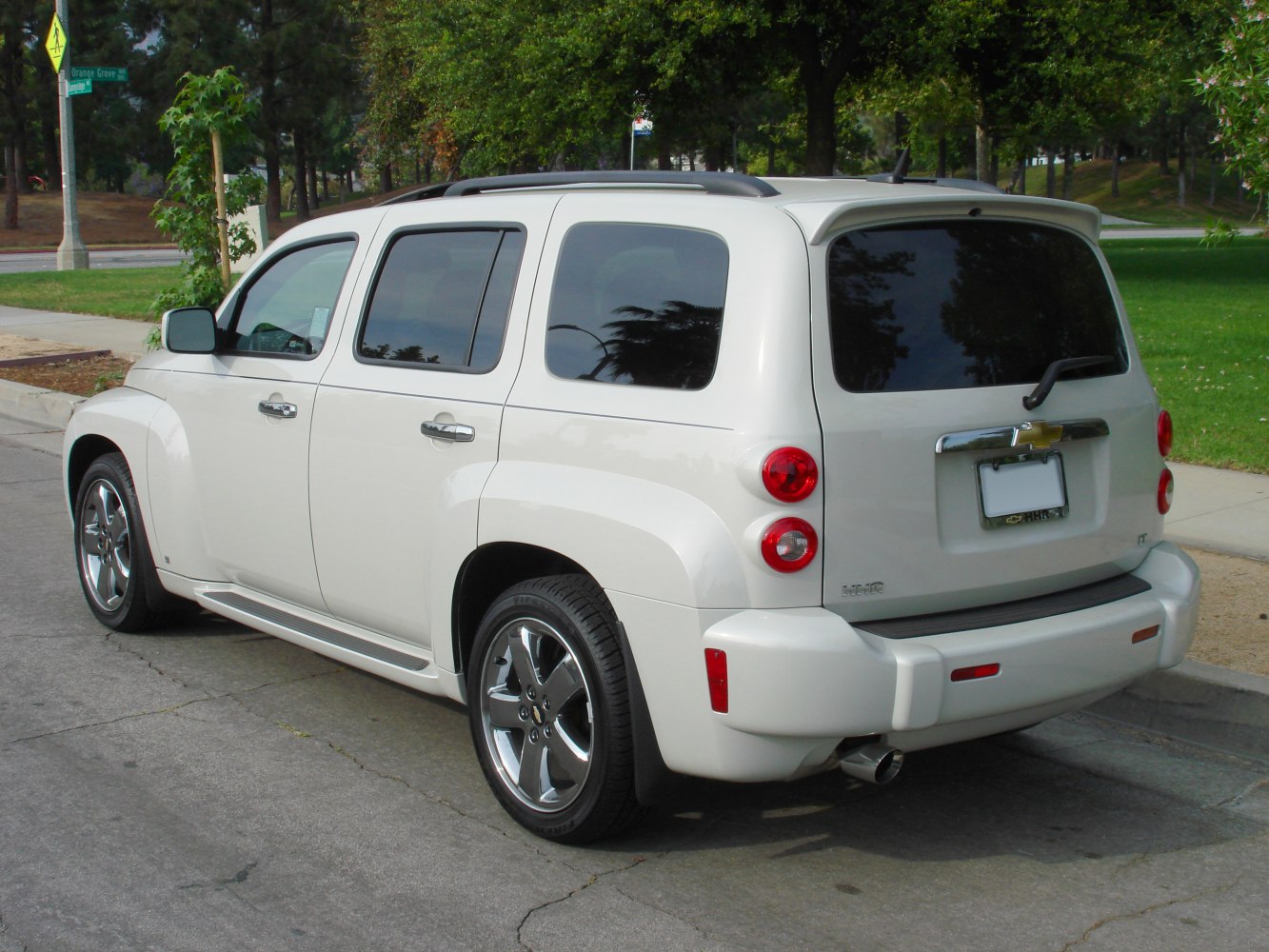 Rear side with roof rails, alloy wheels, tinted windows, and dual round taillights.