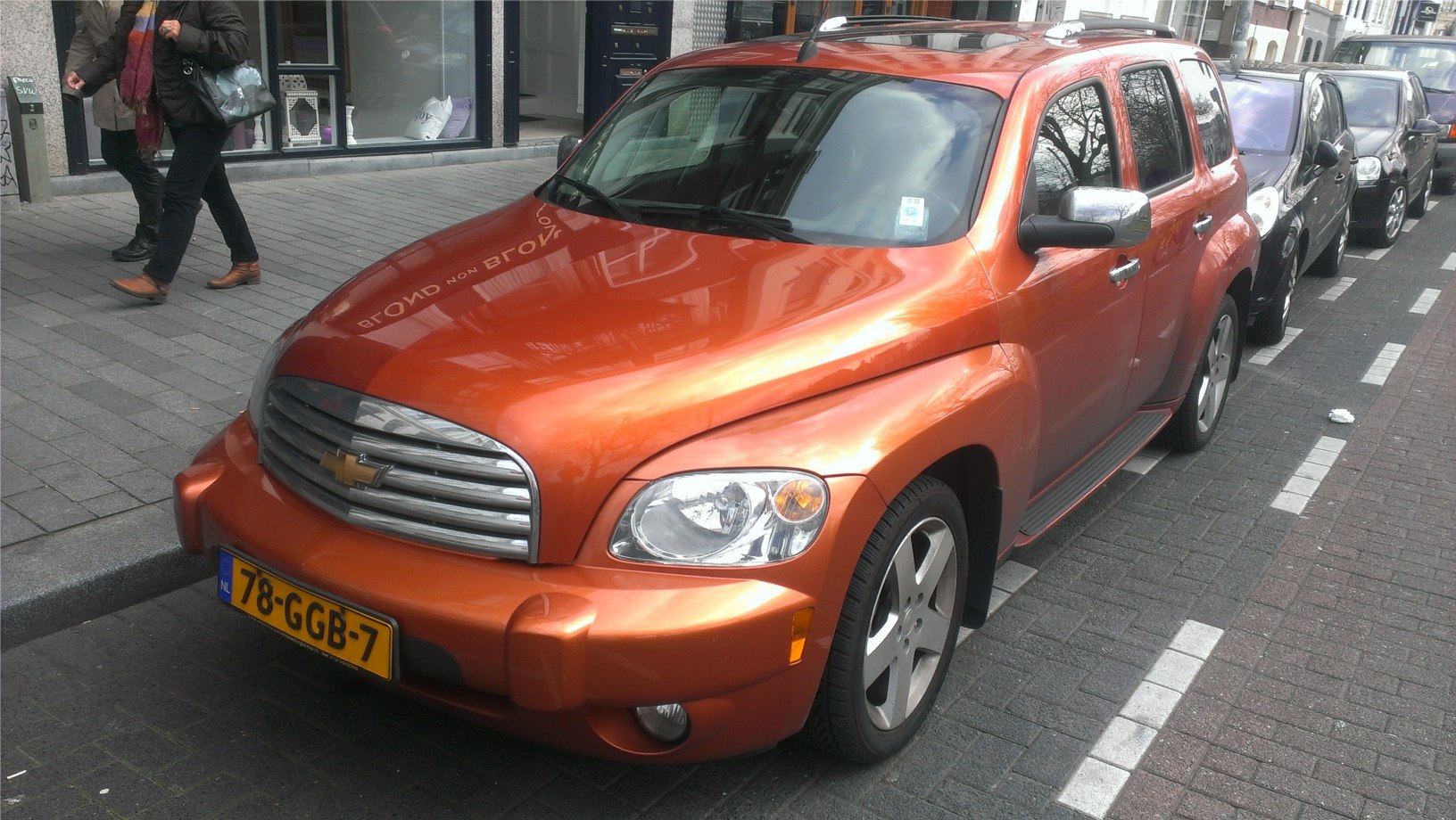 Distinctive front grille and headlight design on bright orange car