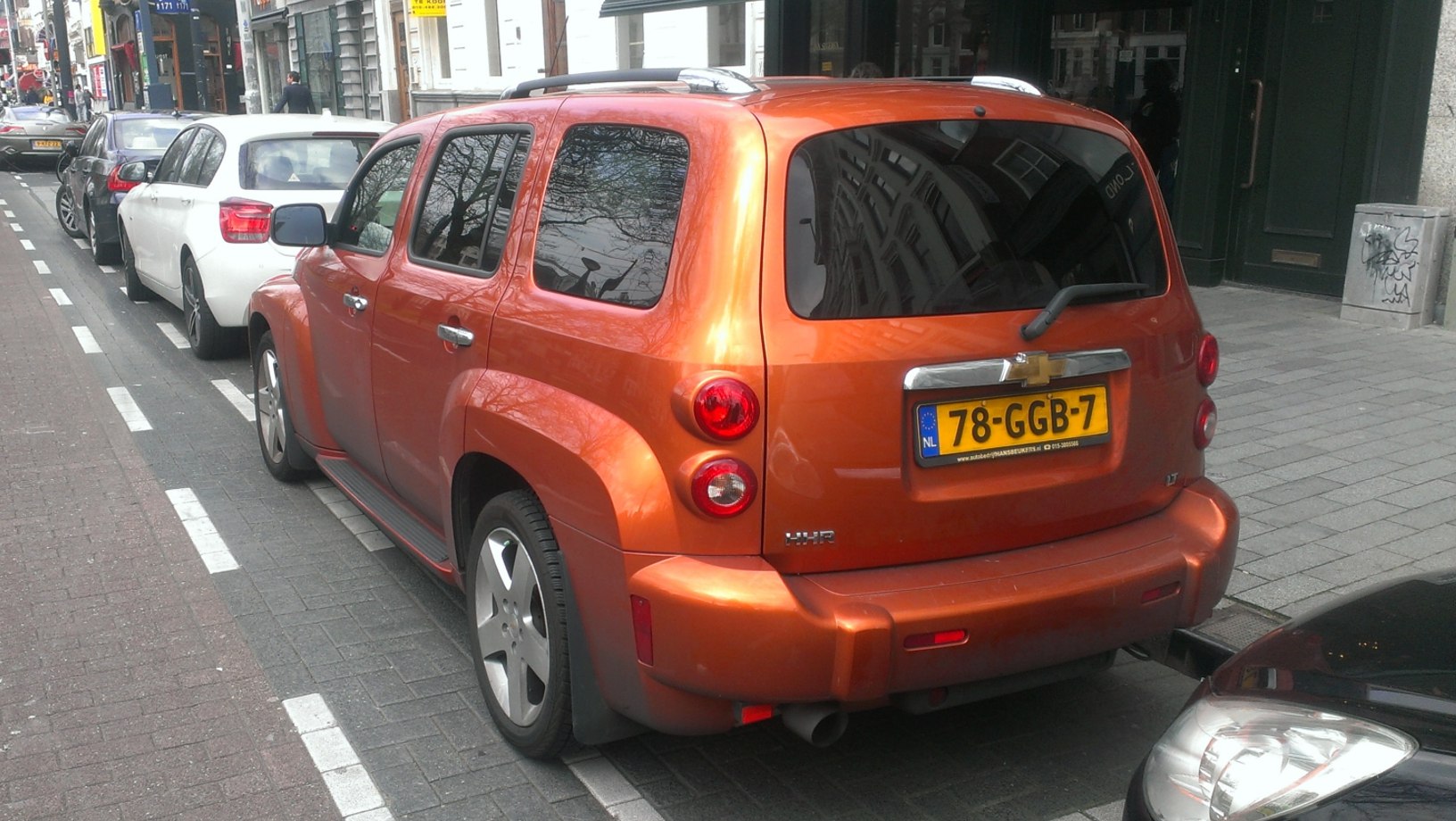 Orange vehicle rear with round taillights and tinted windows