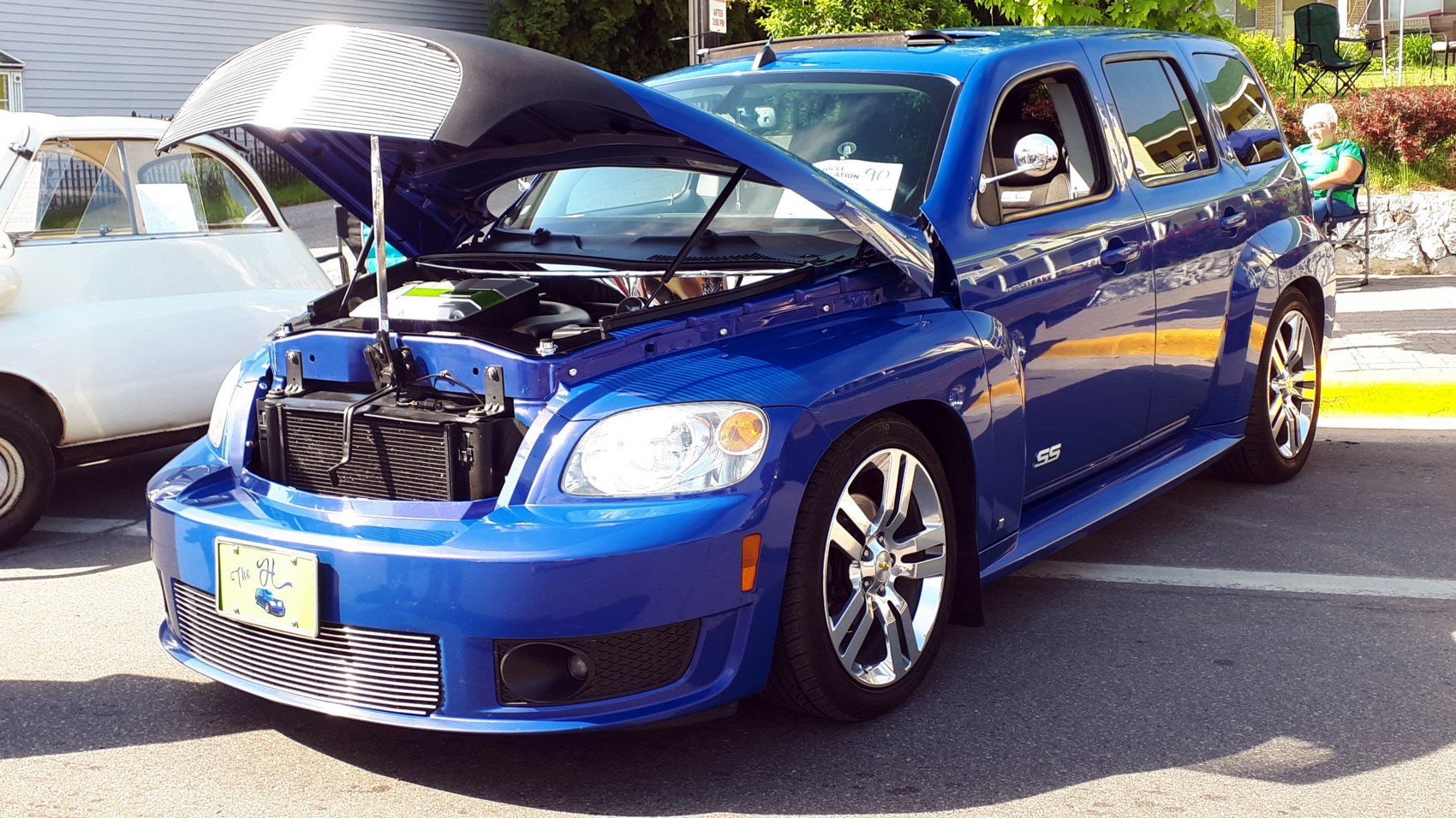 Blue sporty wagon with open hood showing front grille and headlights