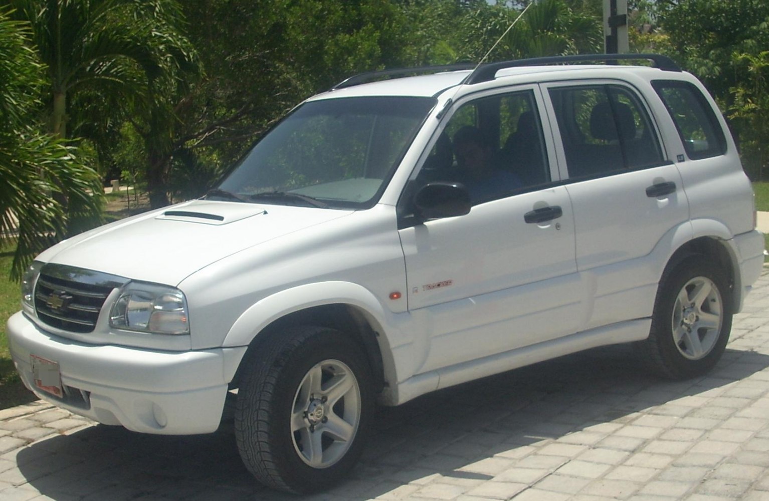 White compact SUV with hood scoop, roof rails, and alloy wheels