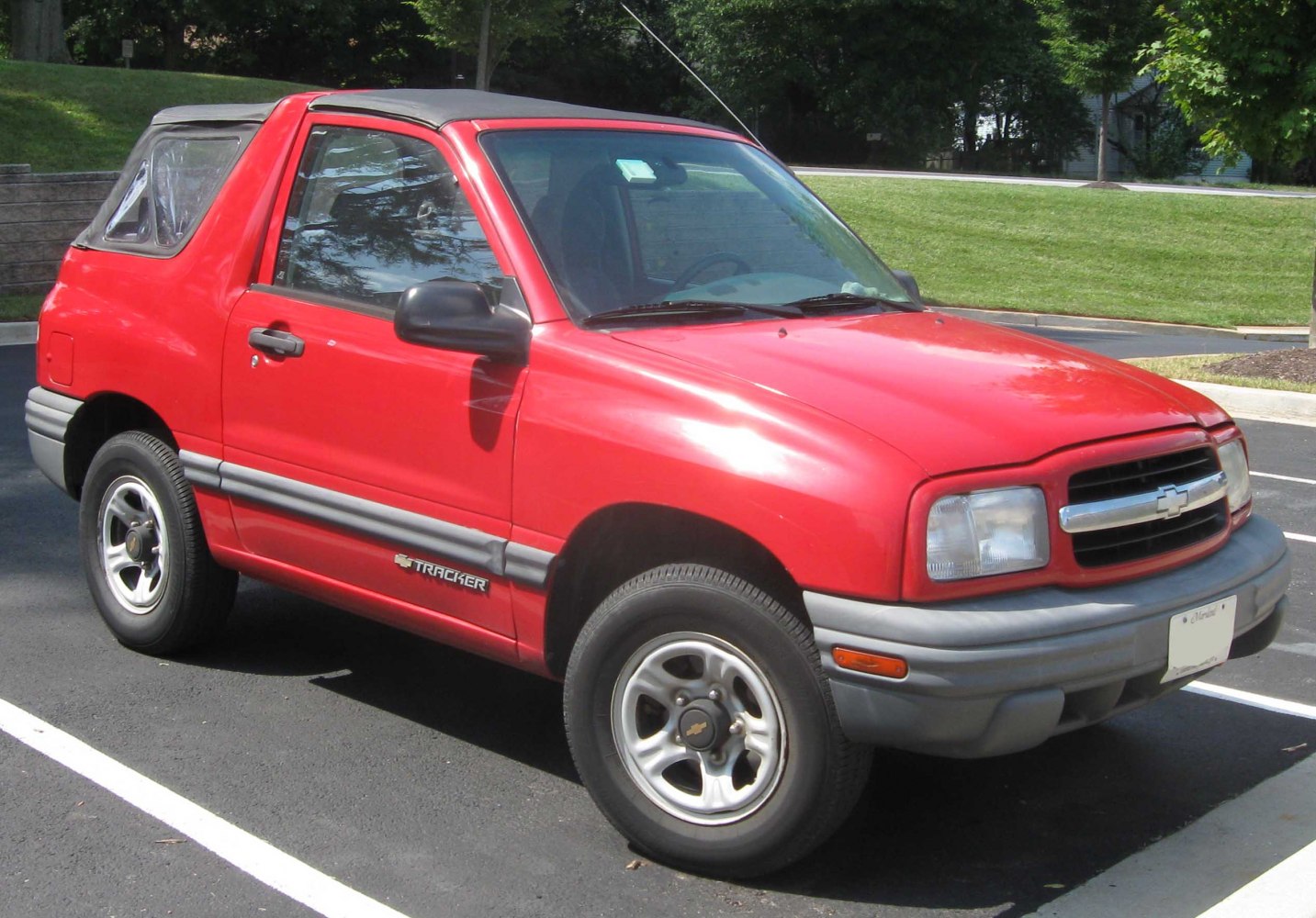 Red compact convertible SUV with black soft top parked outdoors