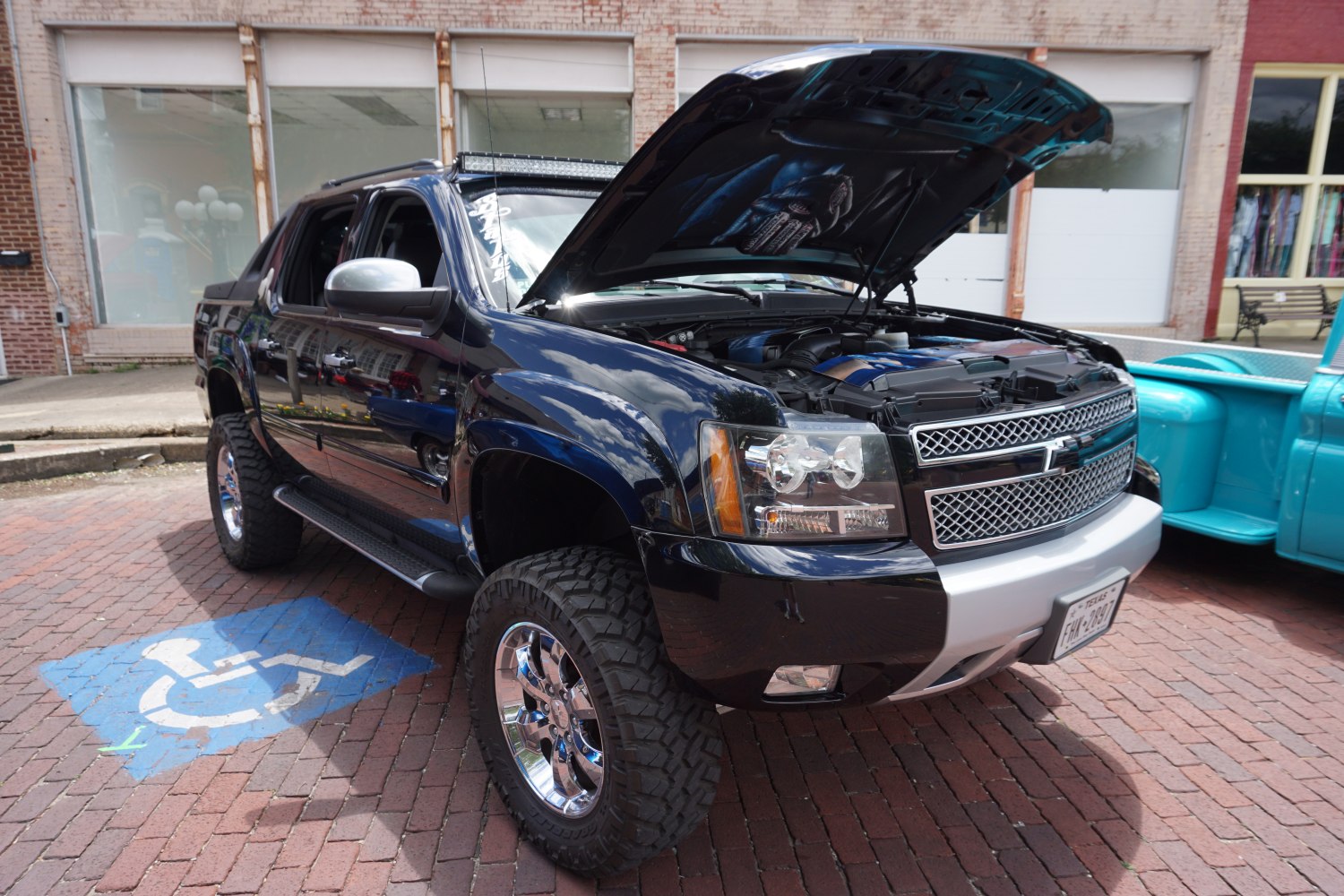 Lifted suspension and open hood showing engine bay
