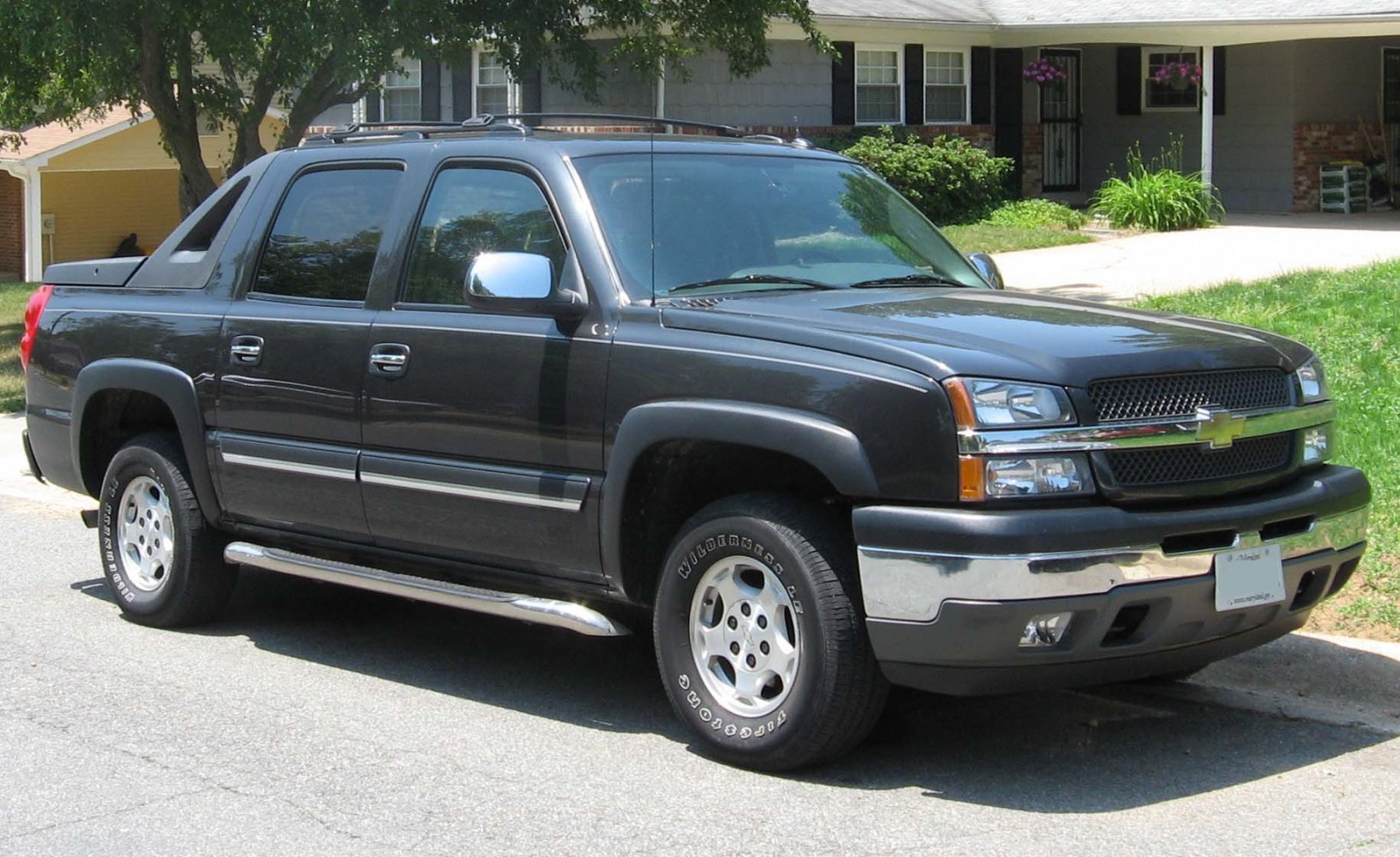 Crew cab pickup with chrome side steps and prominent front grille