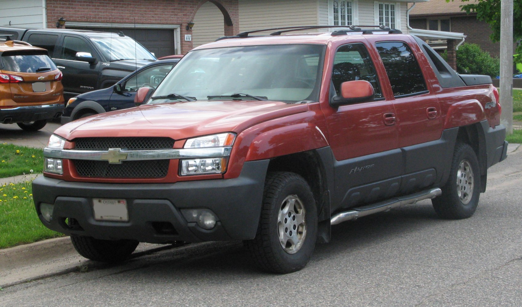 Red modern pickup truck from front side with robust black bumper and alloy wheels