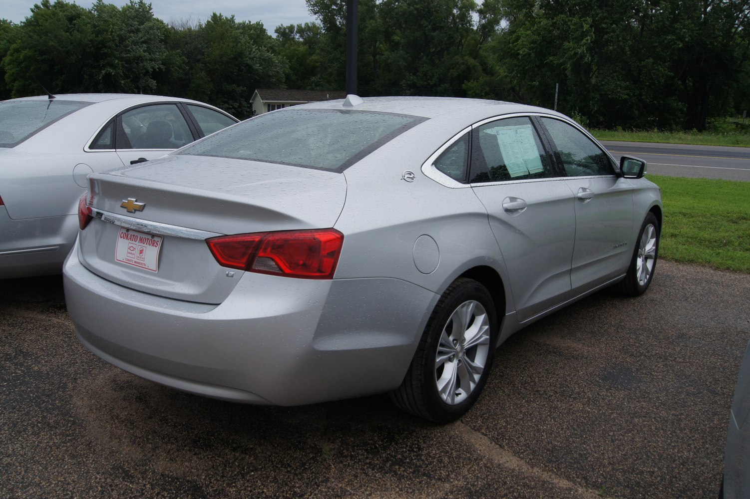 Silver sedan rear side view with distinctive taillights and alloy wheels