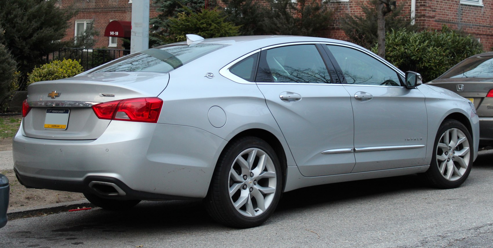 Silver sedan rear and side view with taillights and chrome detailing