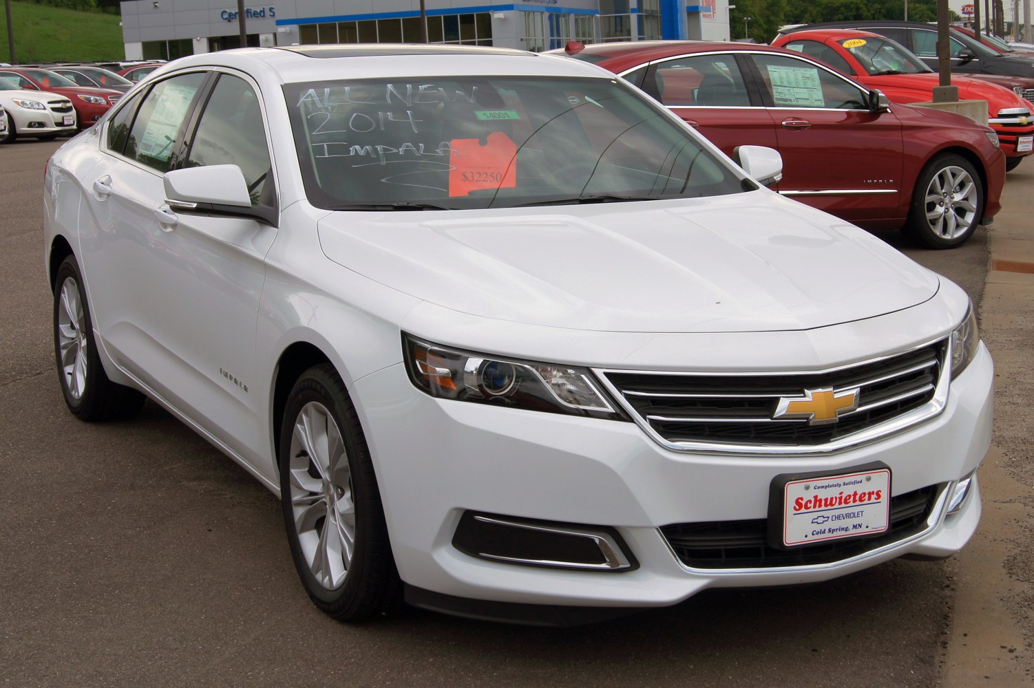 Front angled view of a sleek mid-sized sedan with distinctive grille and headlights