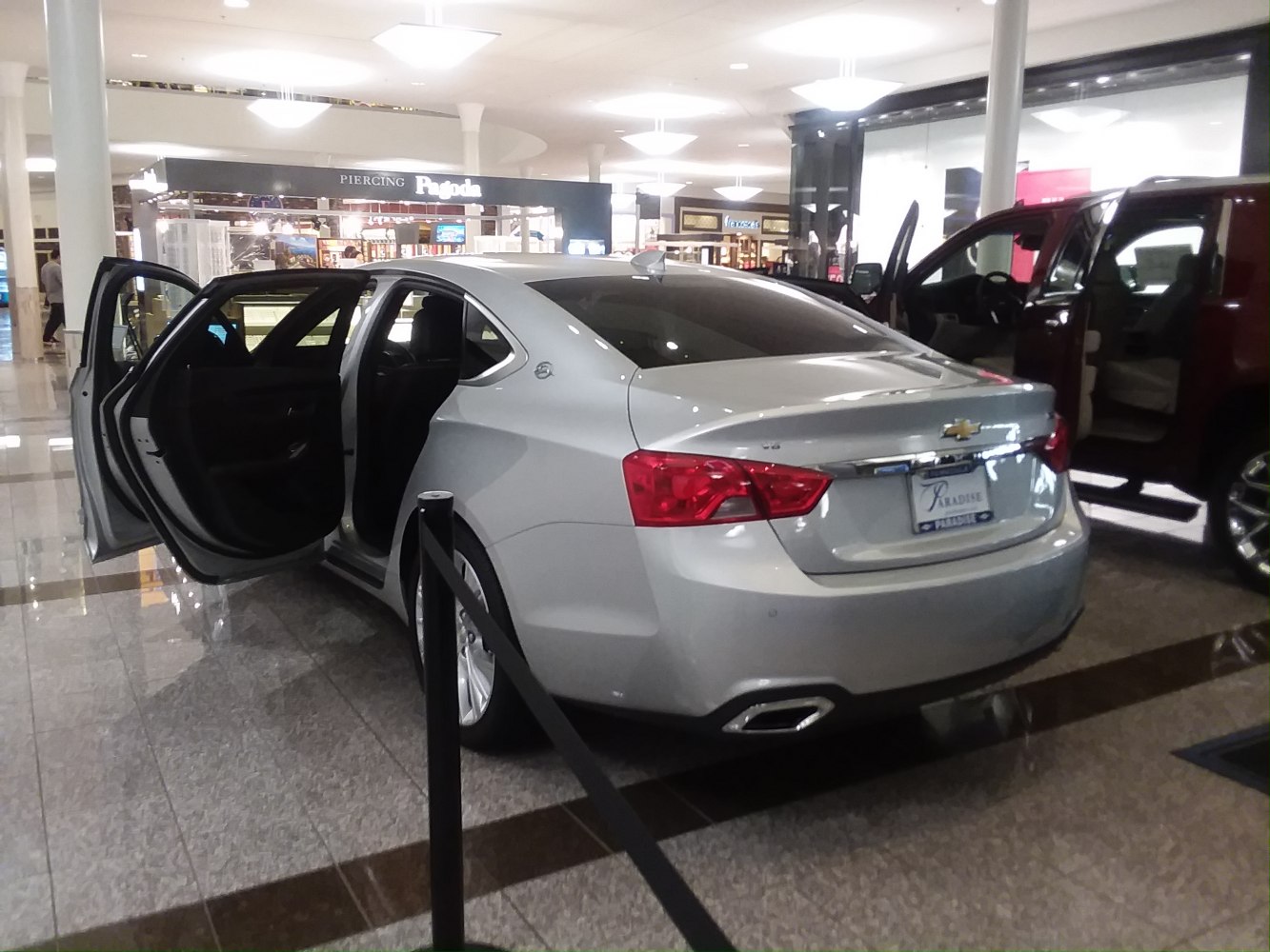 Silver sedan rear side view with open front and rear doors