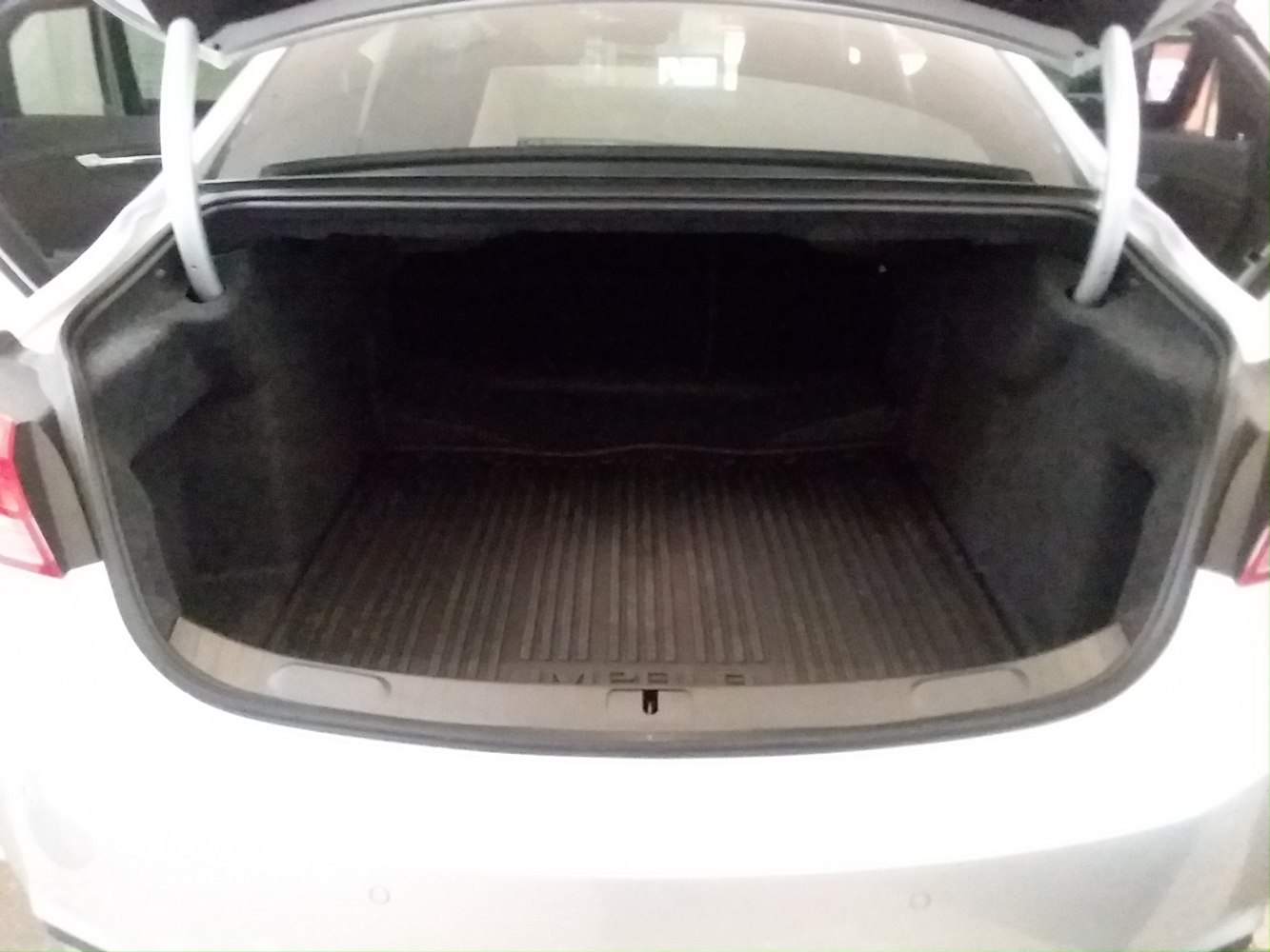 Spacious empty trunk with ribbed rubber mat and side compartments