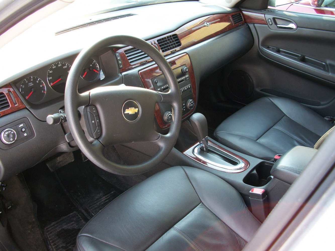 Leather seats, wood trim dashboard, steering wheel with controls, automatic gear shift