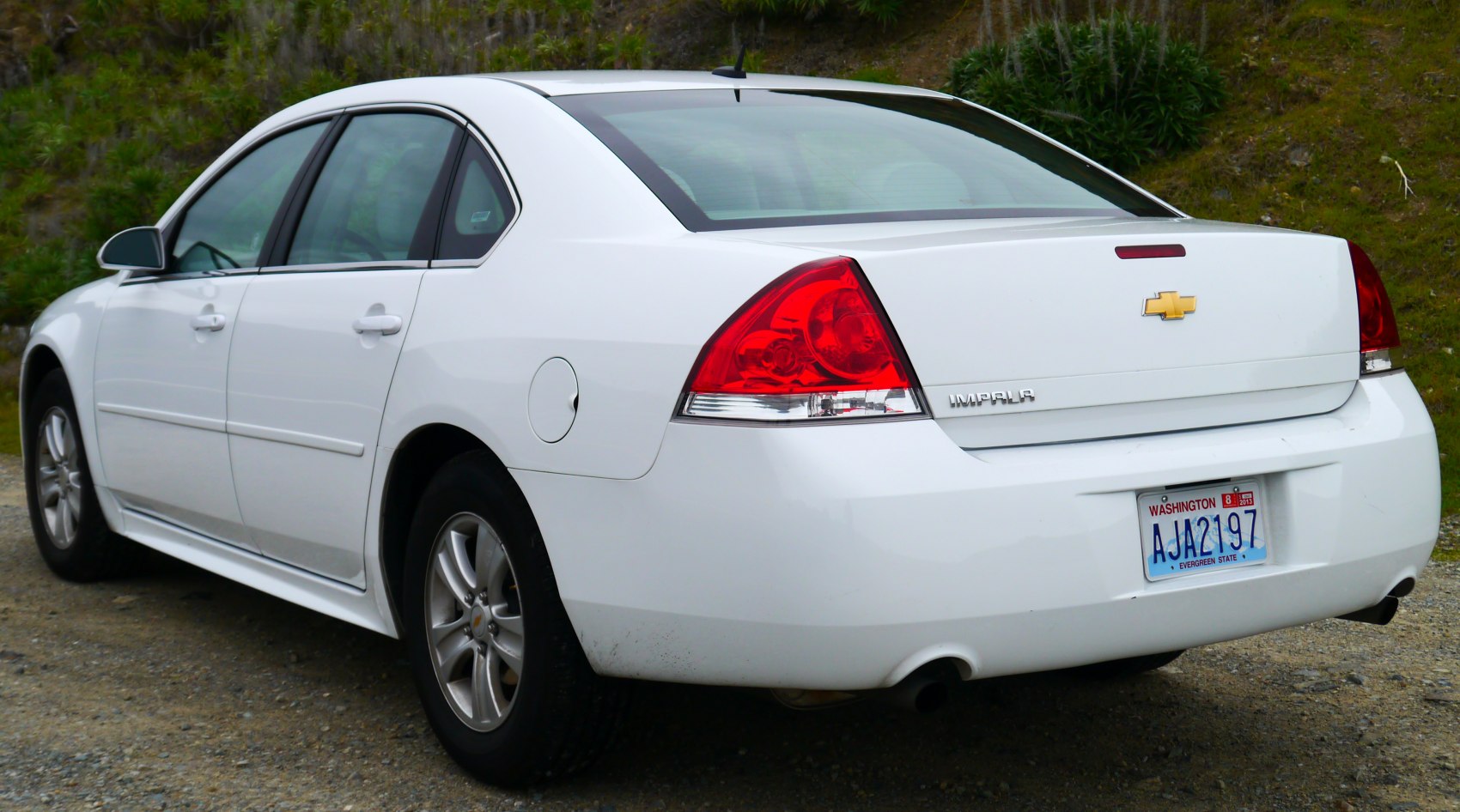 White rear sedan with red tail lights and alloy wheels