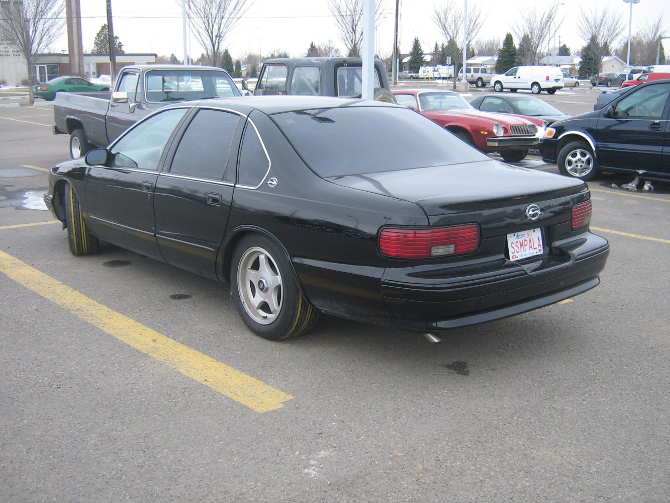Black full-size sedan rear side with tinted windows and red taillights