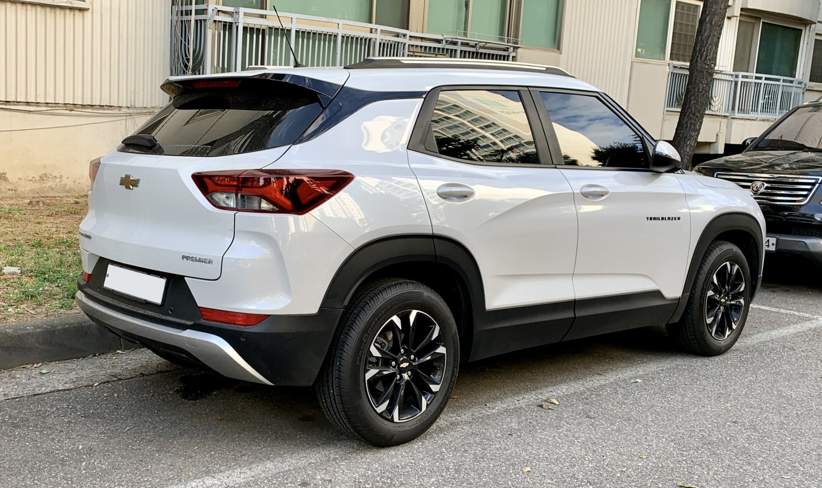 Rear side view of white SUV with black alloy wheels